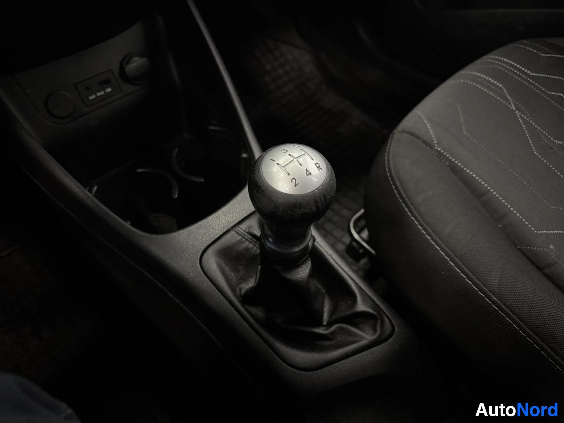 Manual transmission gear shift knob with five-speed gearbox visible in interior