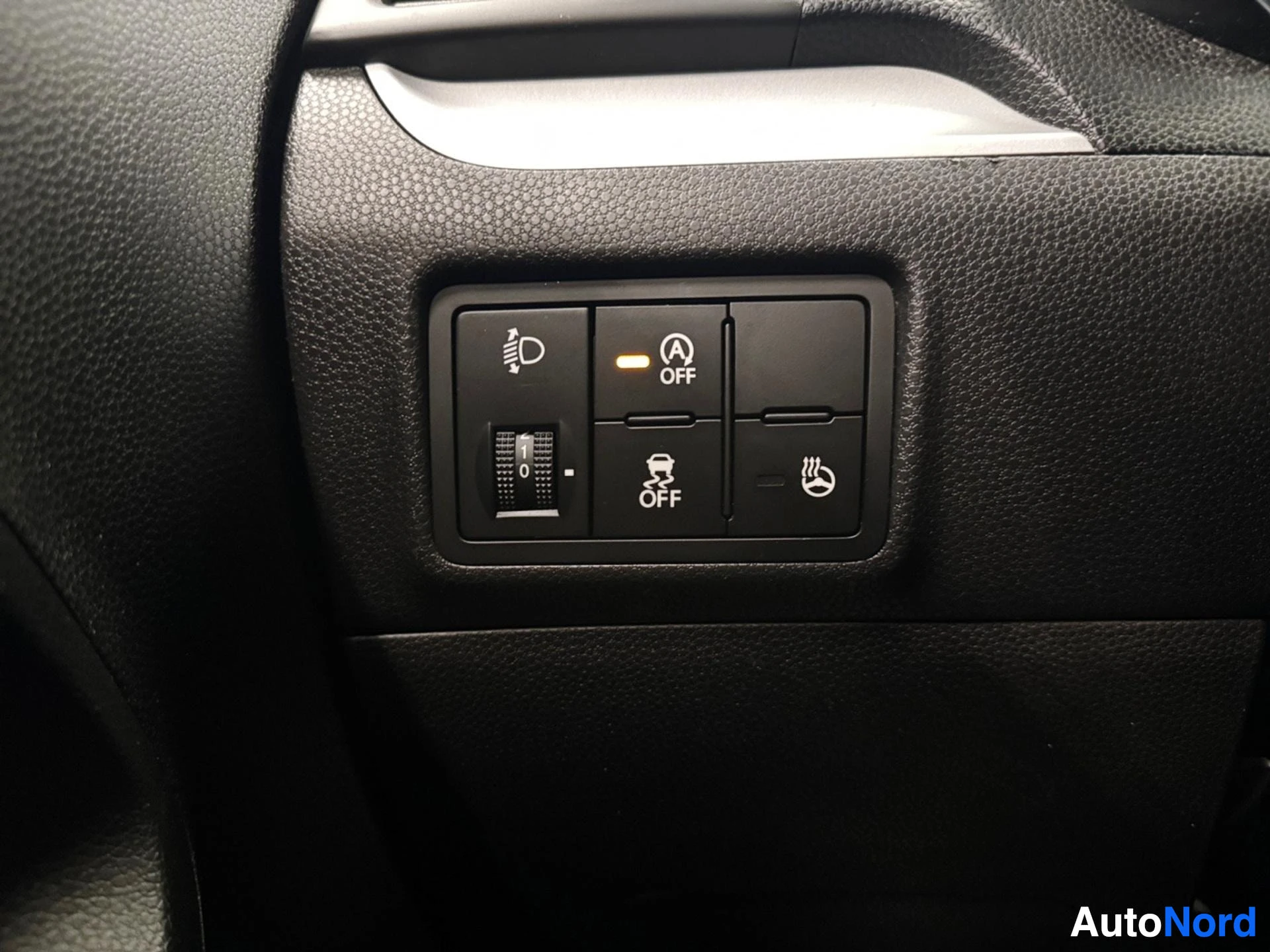 Dashboard control buttons for headlights, parking assist, and heated seat functions