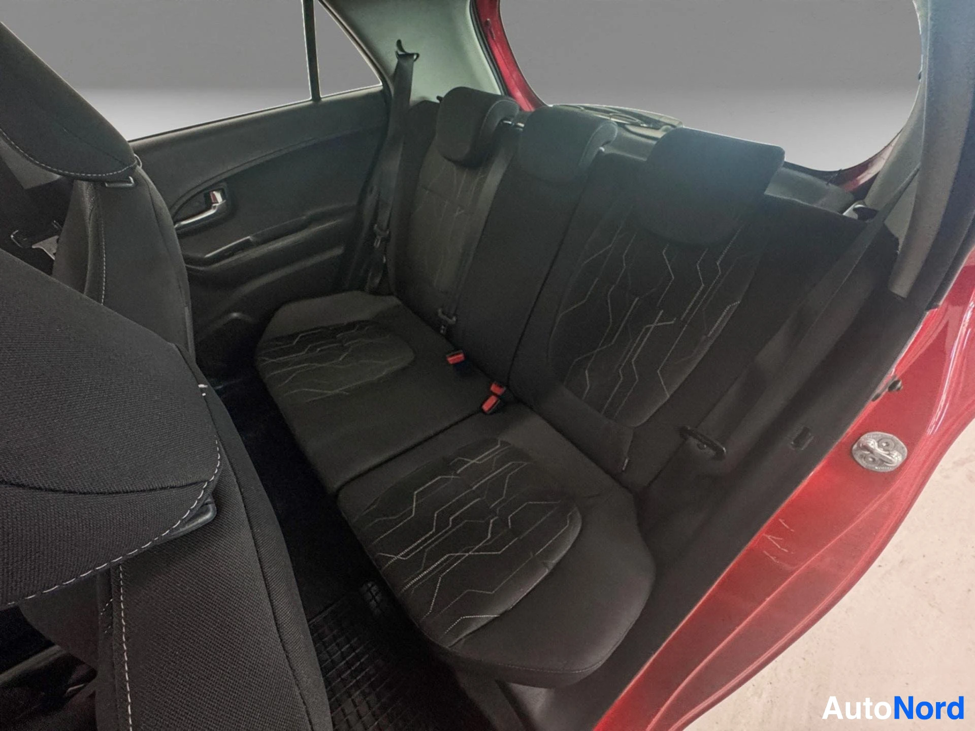 Red Kia Picanto rear seat with black upholstered seating and red door frame