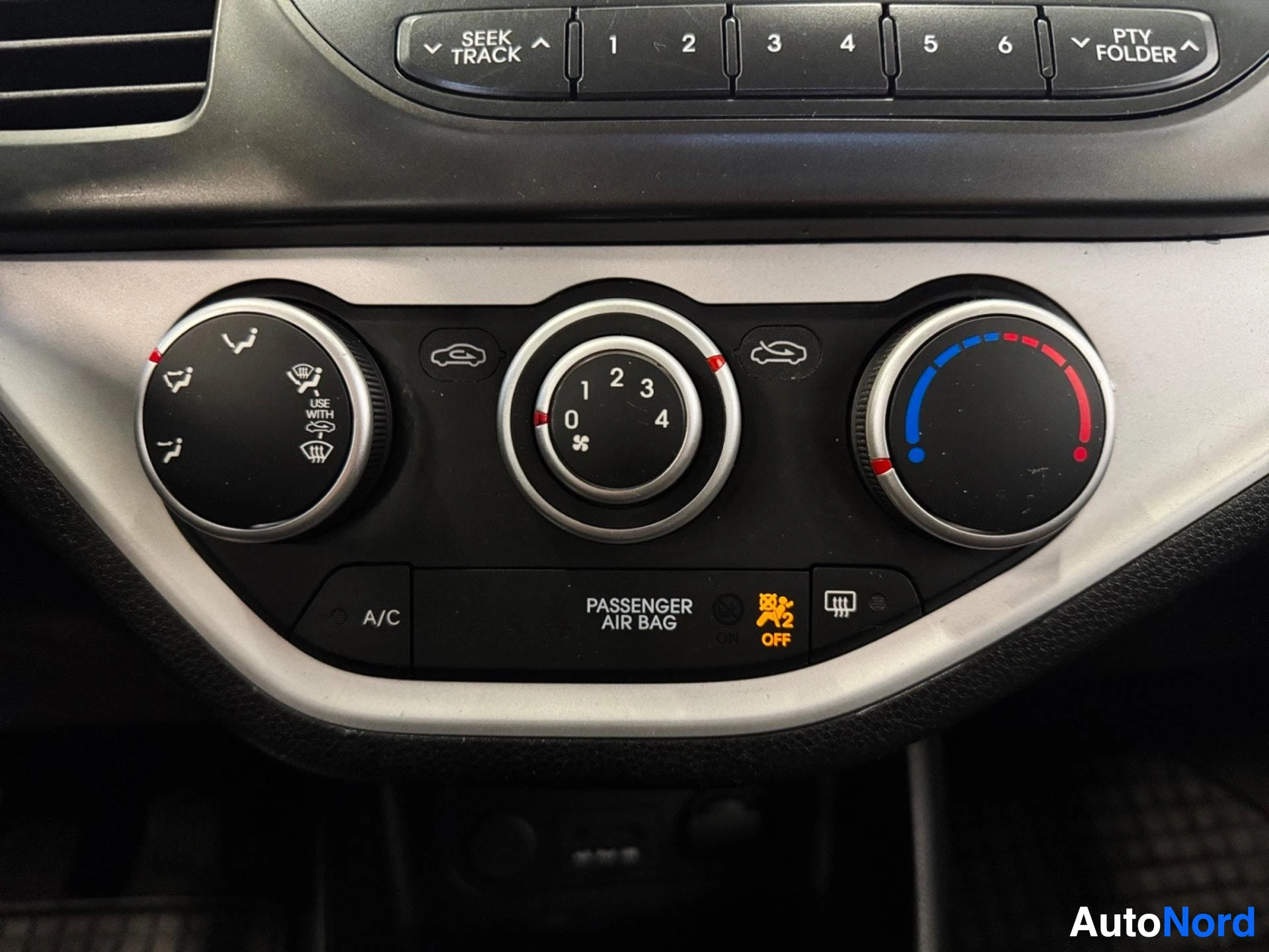 Climate control panel with temperature dial and air conditioning buttons