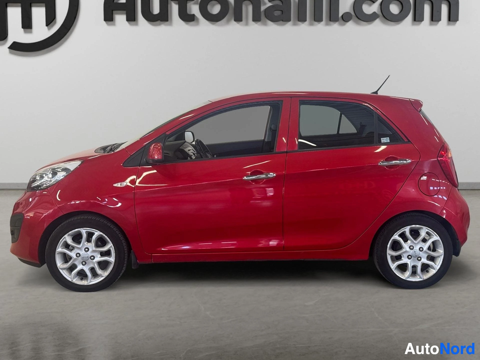 Red Kia Picanto hatchback viewed from driver side profile