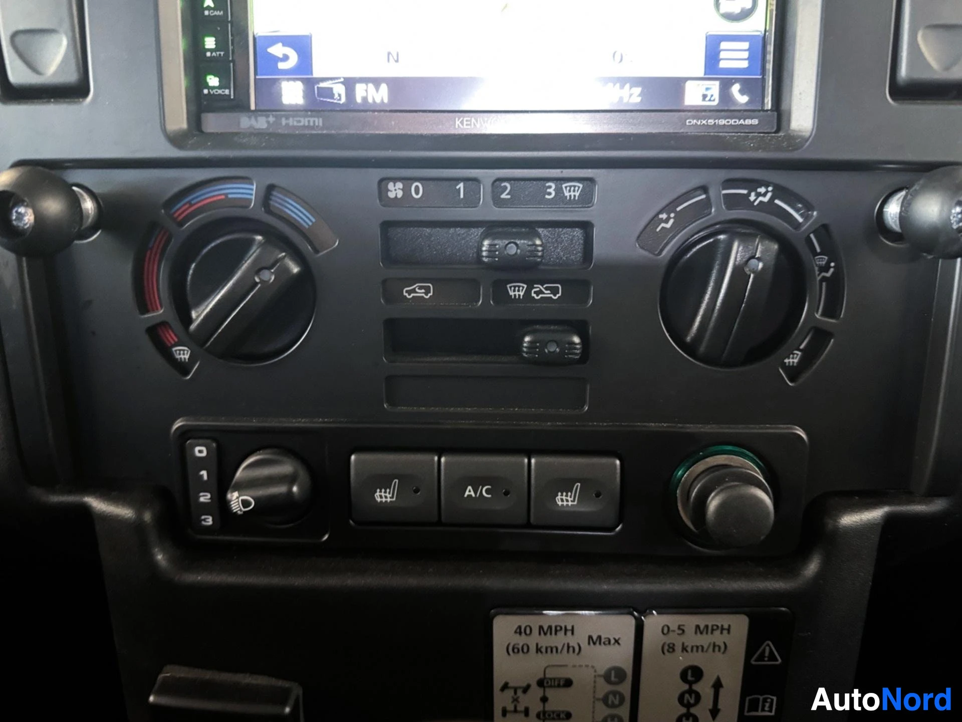 Värikäs ilmastoinnin säätöpaneeli ja Kenwood-autostereo näyttö.