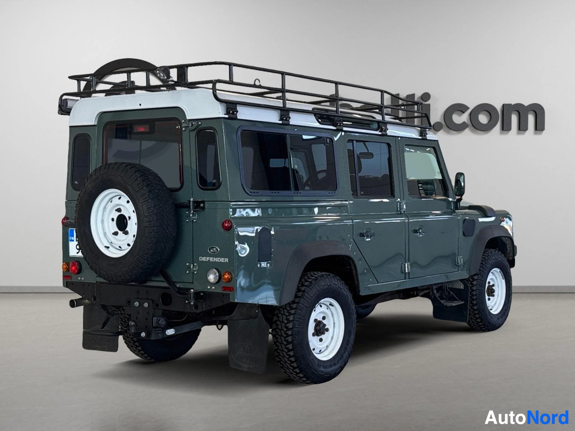 Vihreä Land Rover Defender 110 SW takaa oikealta diagonaalista kulmasta
