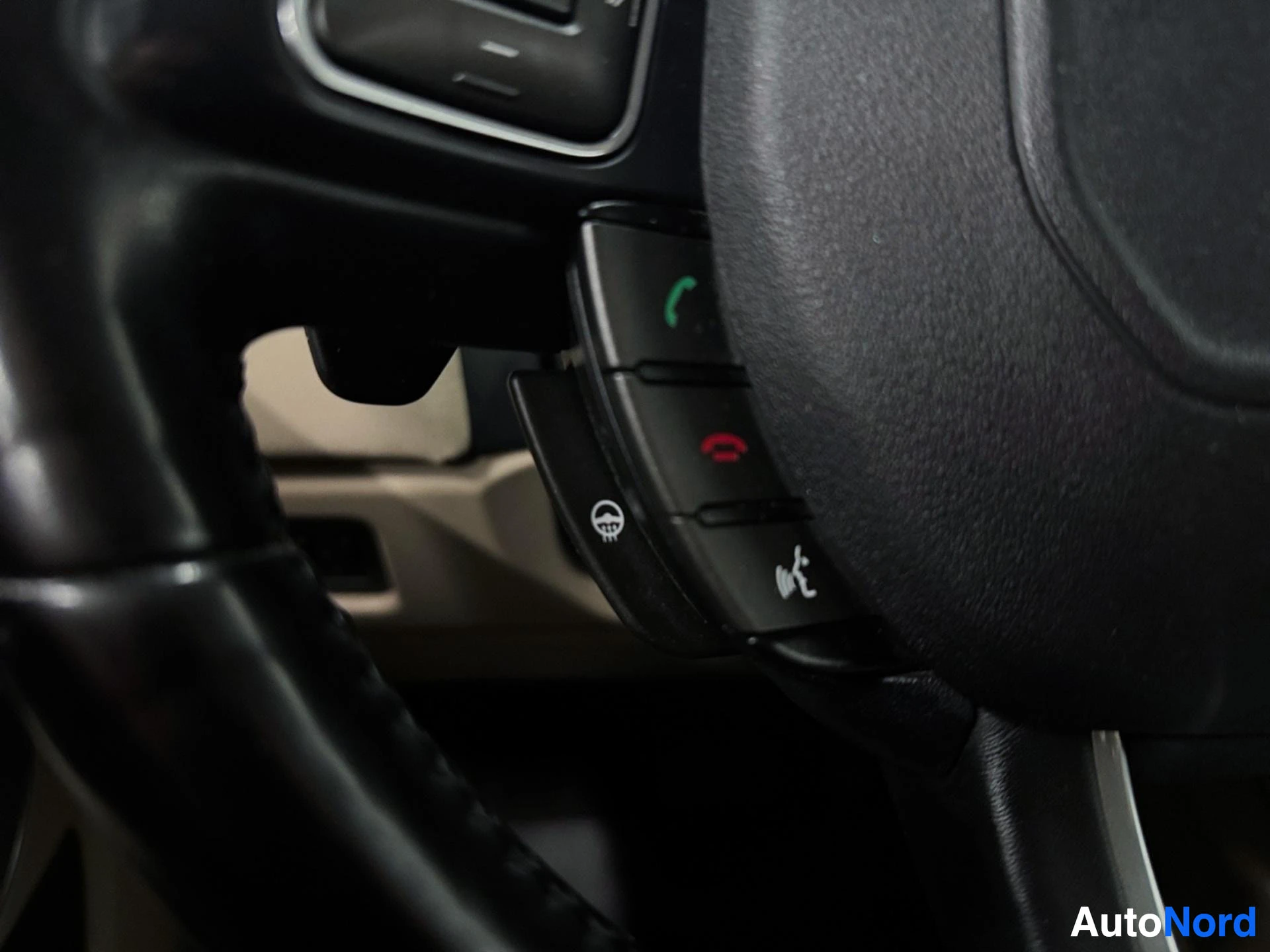 Steering wheel controls with leather grip and function buttons visible