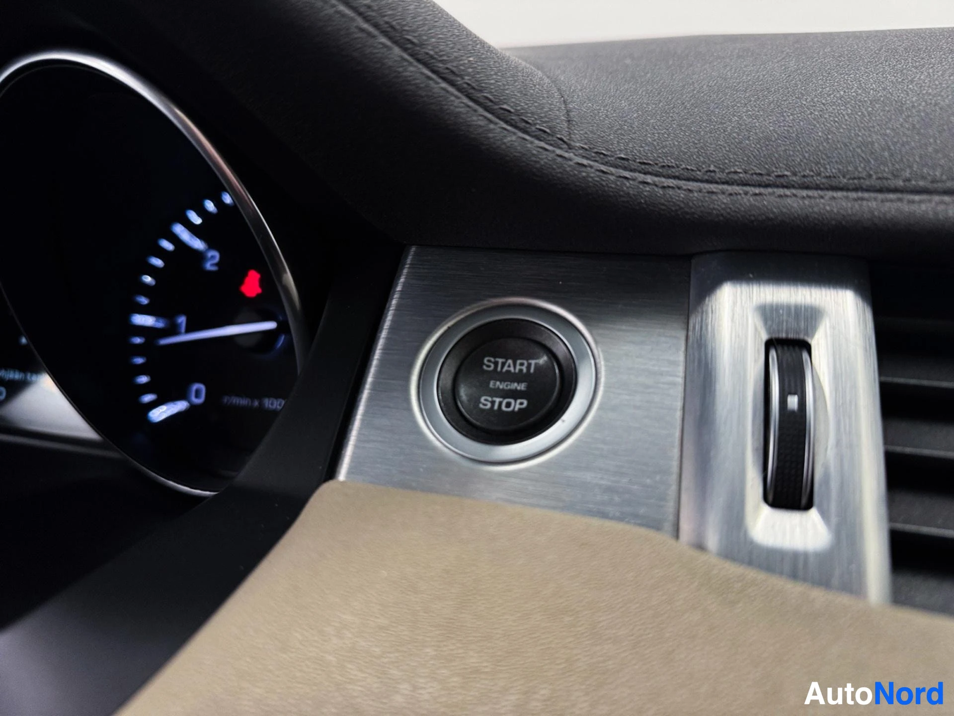 Dashboard showing instrument cluster, engine start stop button and gear shift