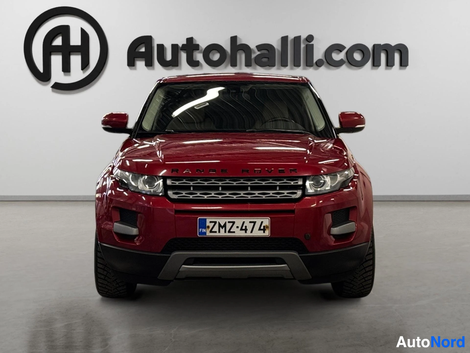 Punainen Range Rover Evoque etulta katsottuna, kojelaudan näkymä.