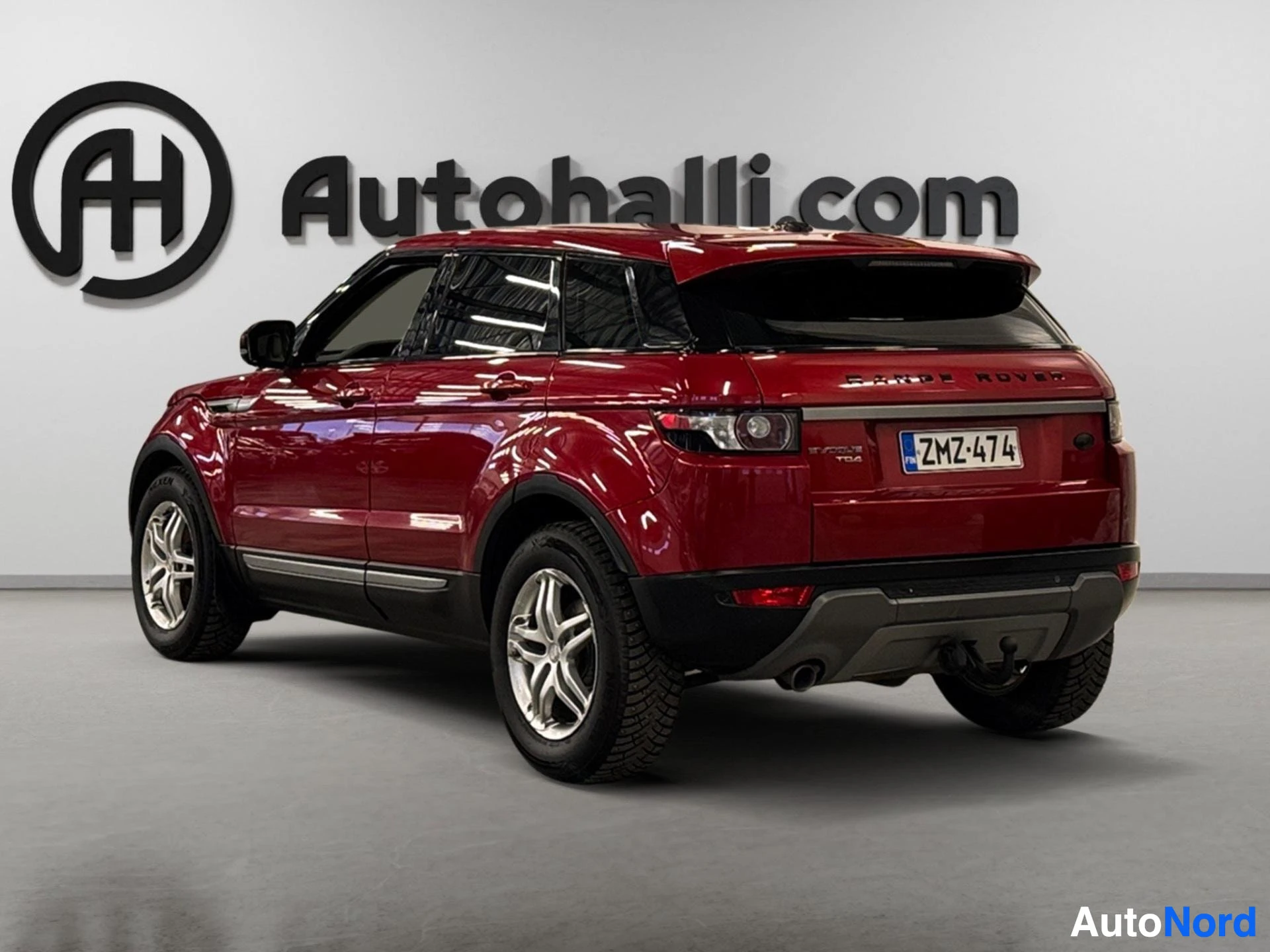 Punainen Range Rover Evoque kuvattu kulmasta, näkyy sivu ja taka-alue