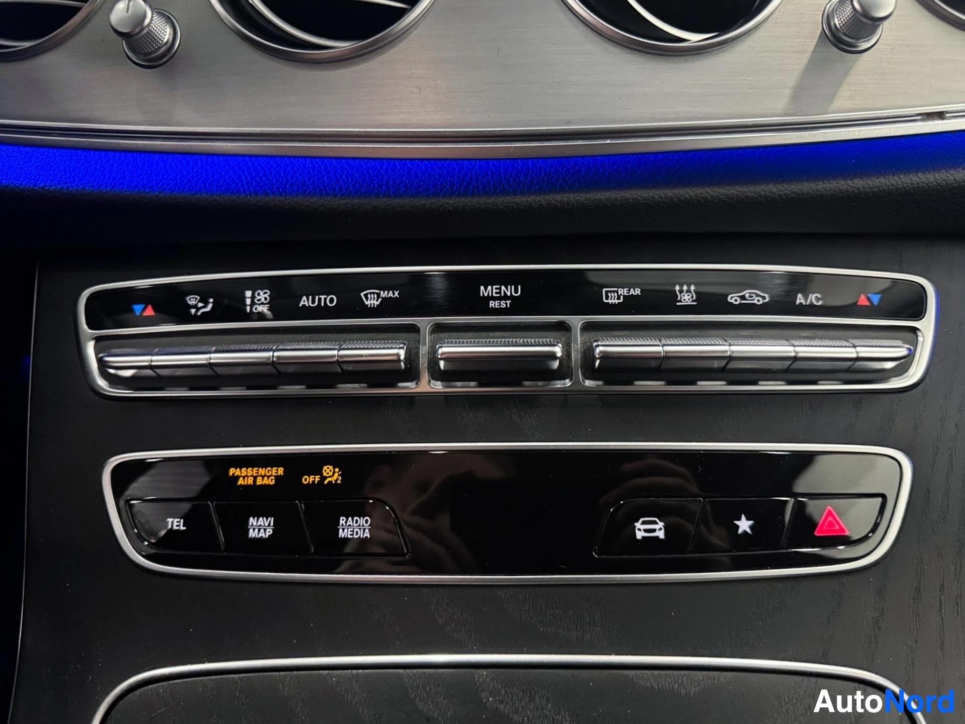 Climate control and media buttons on center console with blue ambient lighting