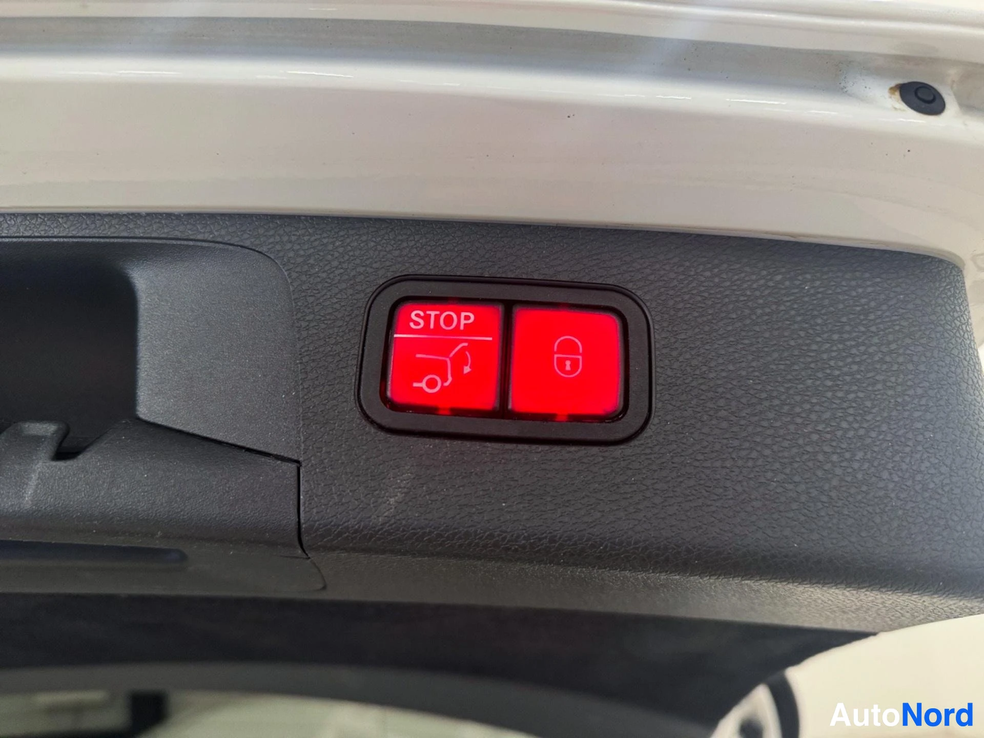 Door panel with red illuminated buttons showing fuel door and lock symbols