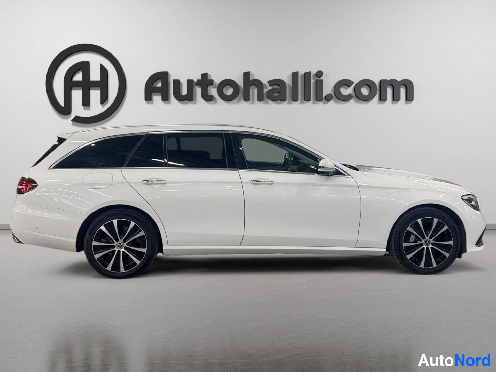 Valkoinen Mercedes-Benz farmari sivusta vasemmalta puolelta näkyvissä