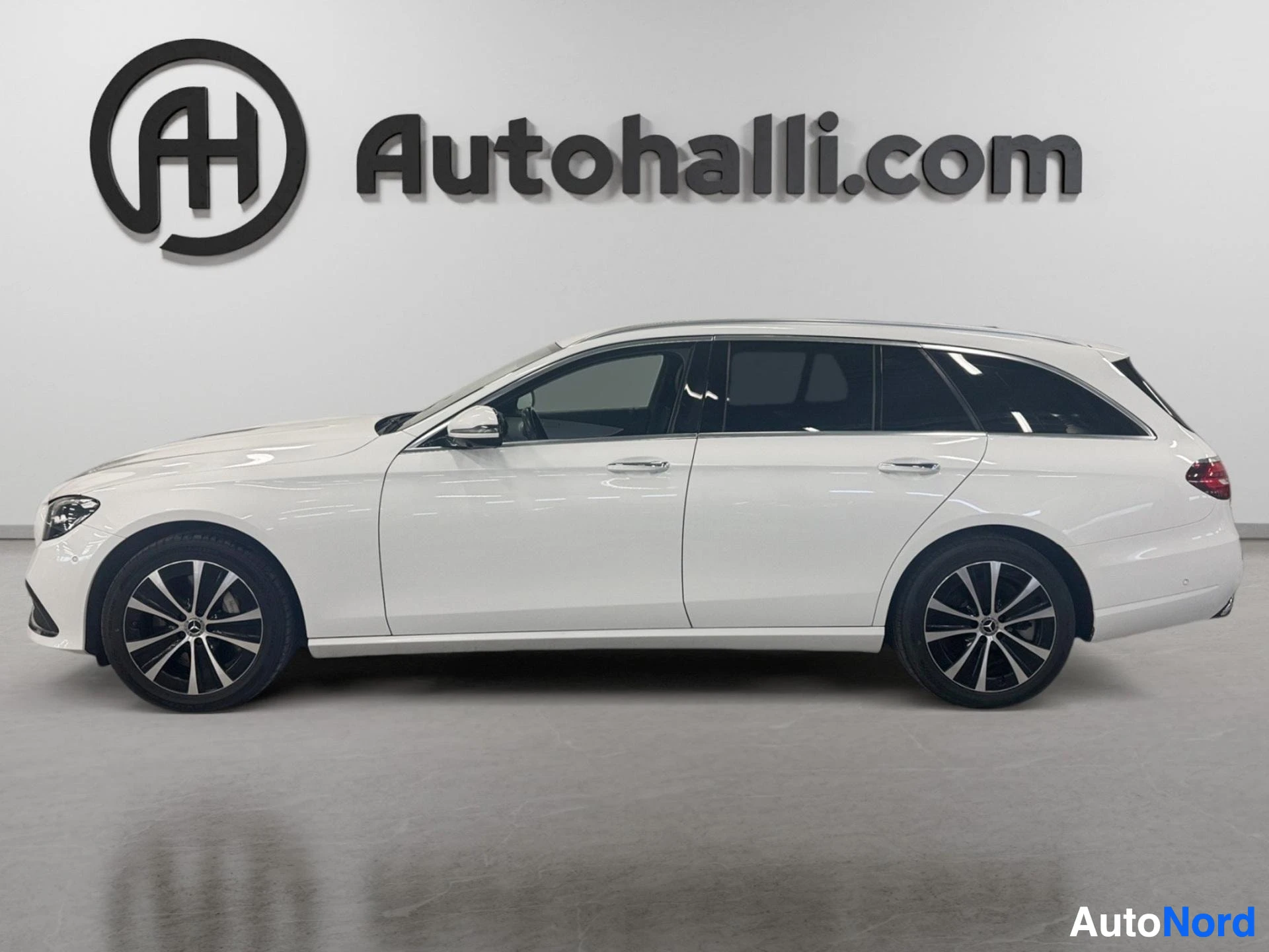Valkoinen Mercedes-Benz farmari sivusta, ovet auki, näkymä vasemmalta