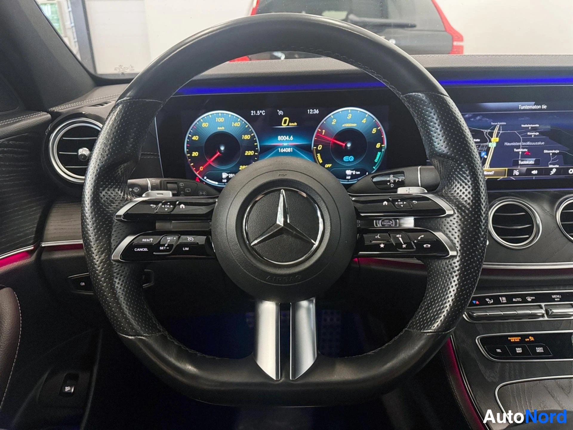 Mercedes-Benz steering wheel with leather grip and dashboard display visible behind