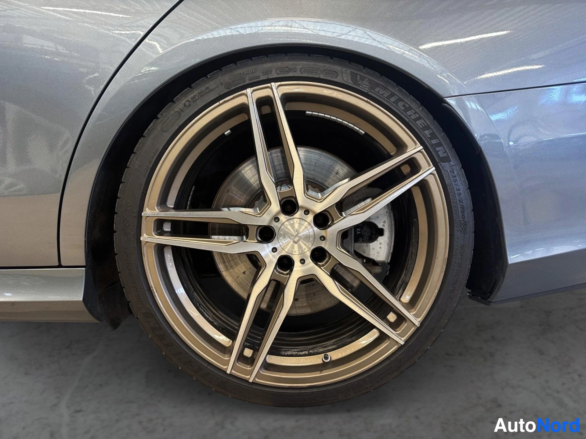Two-tone beige and black alloy wheel with tire on vehicle side