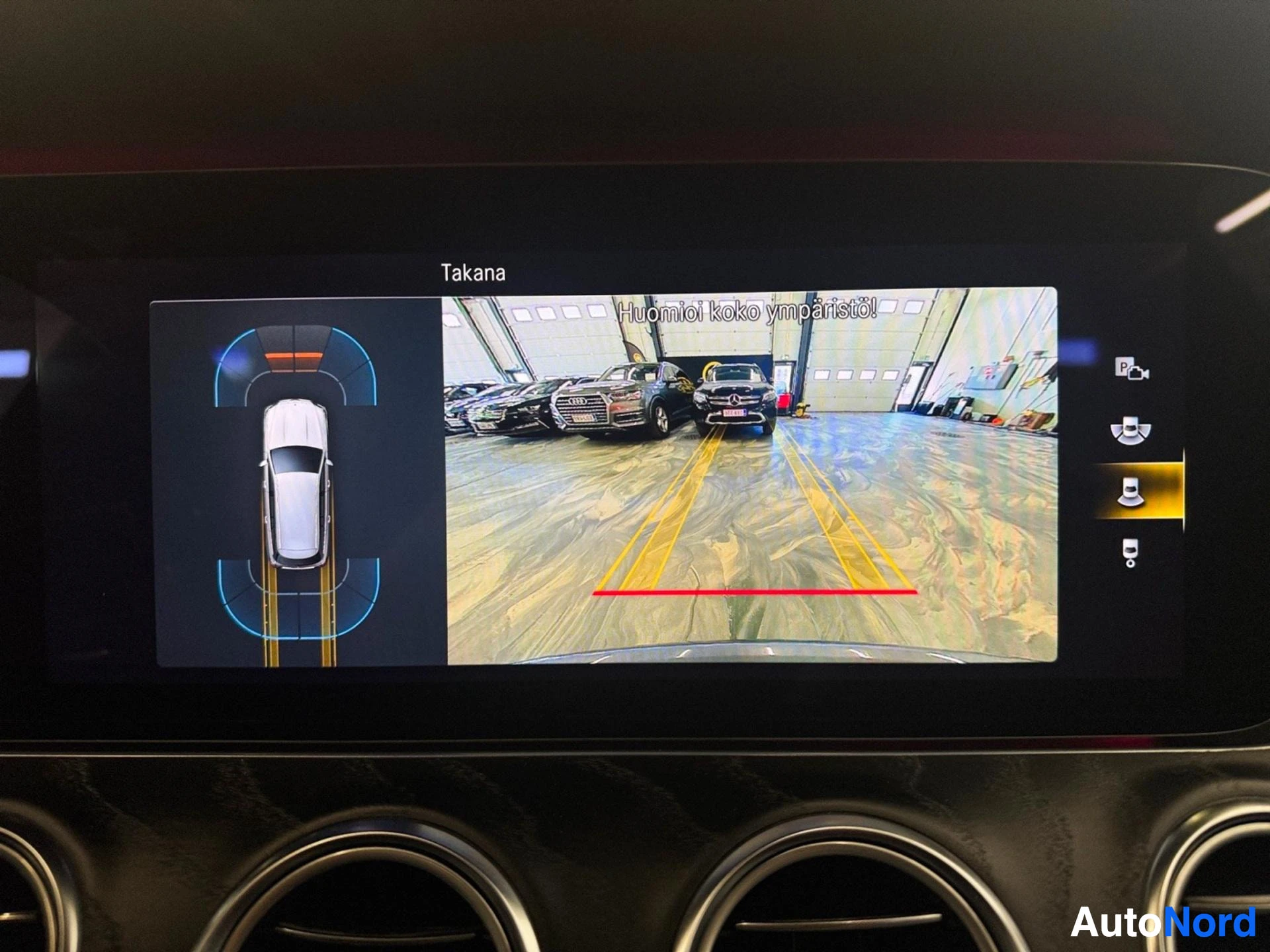 Backup camera view with overhead parking sensor display on widescreen
