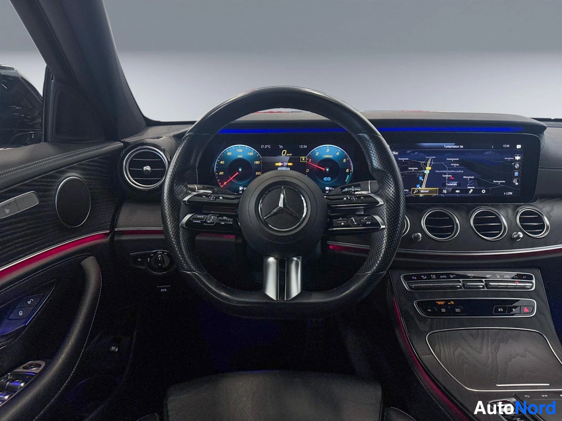 Interior dashboard with steering wheel, digital displays, and ambient lighting