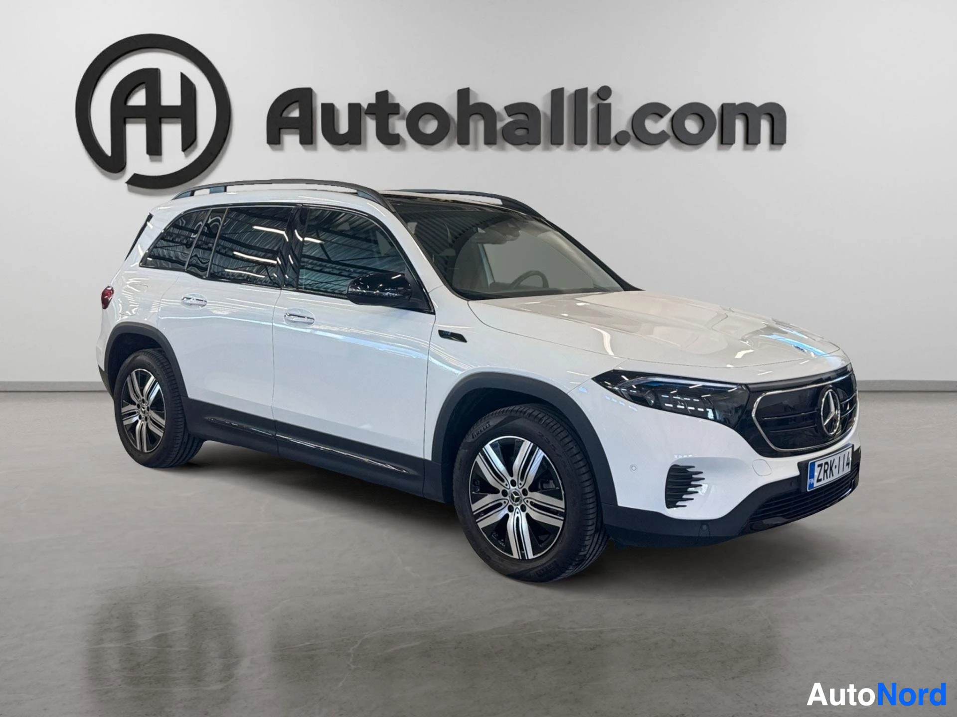 Valkoinen Mercedes-Benz EQB sähköauto sivusta kuvattuna näyttämössä