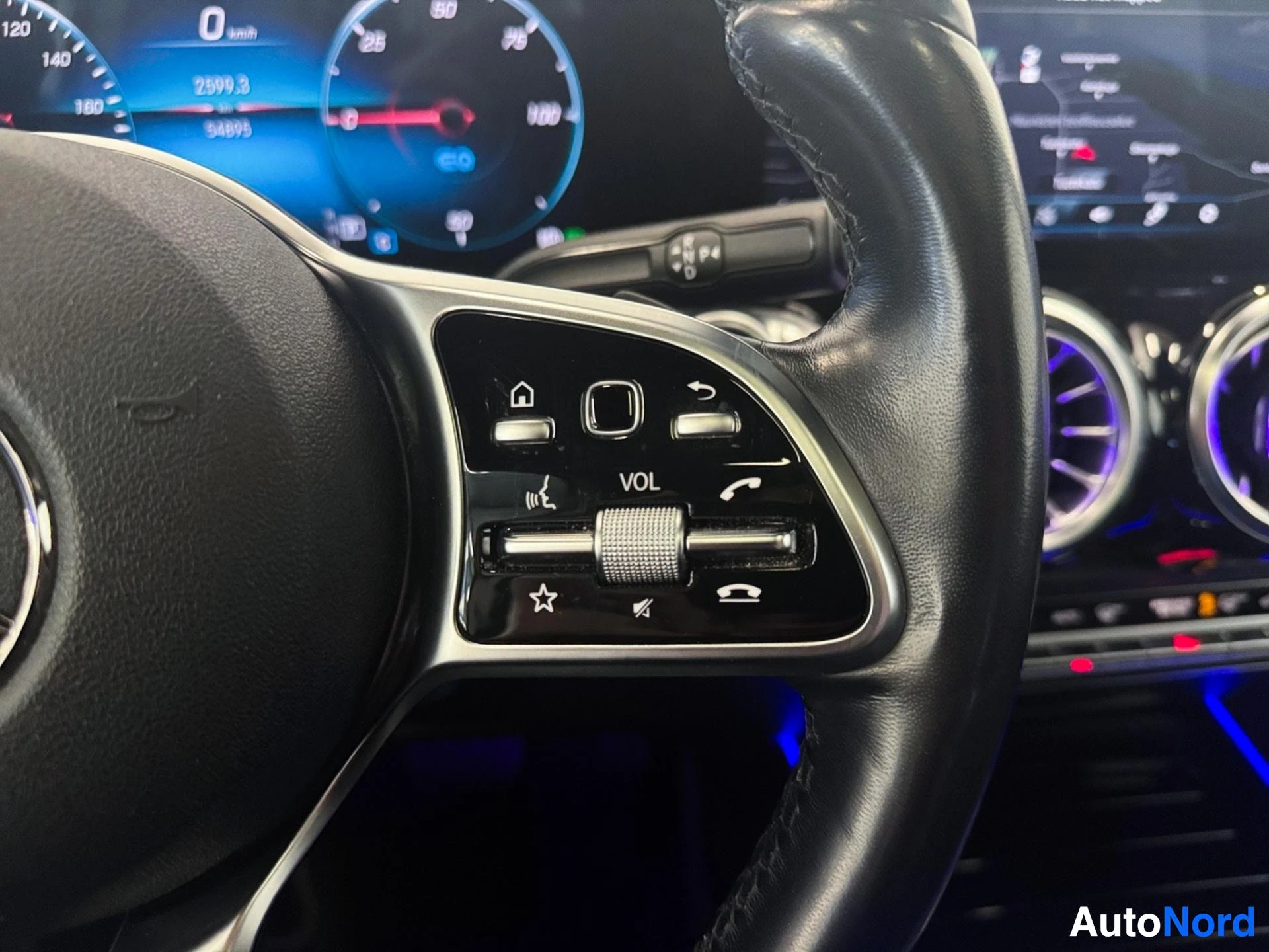 Right steering wheel spoke buttons for phone and audio volume controls.