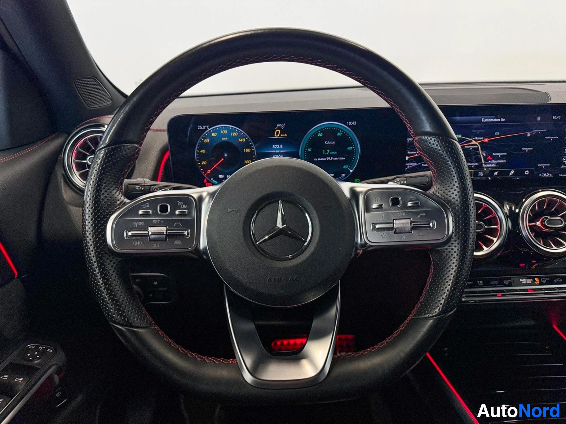 Steering wheel with Mercedes logo and digital instrument cluster in background