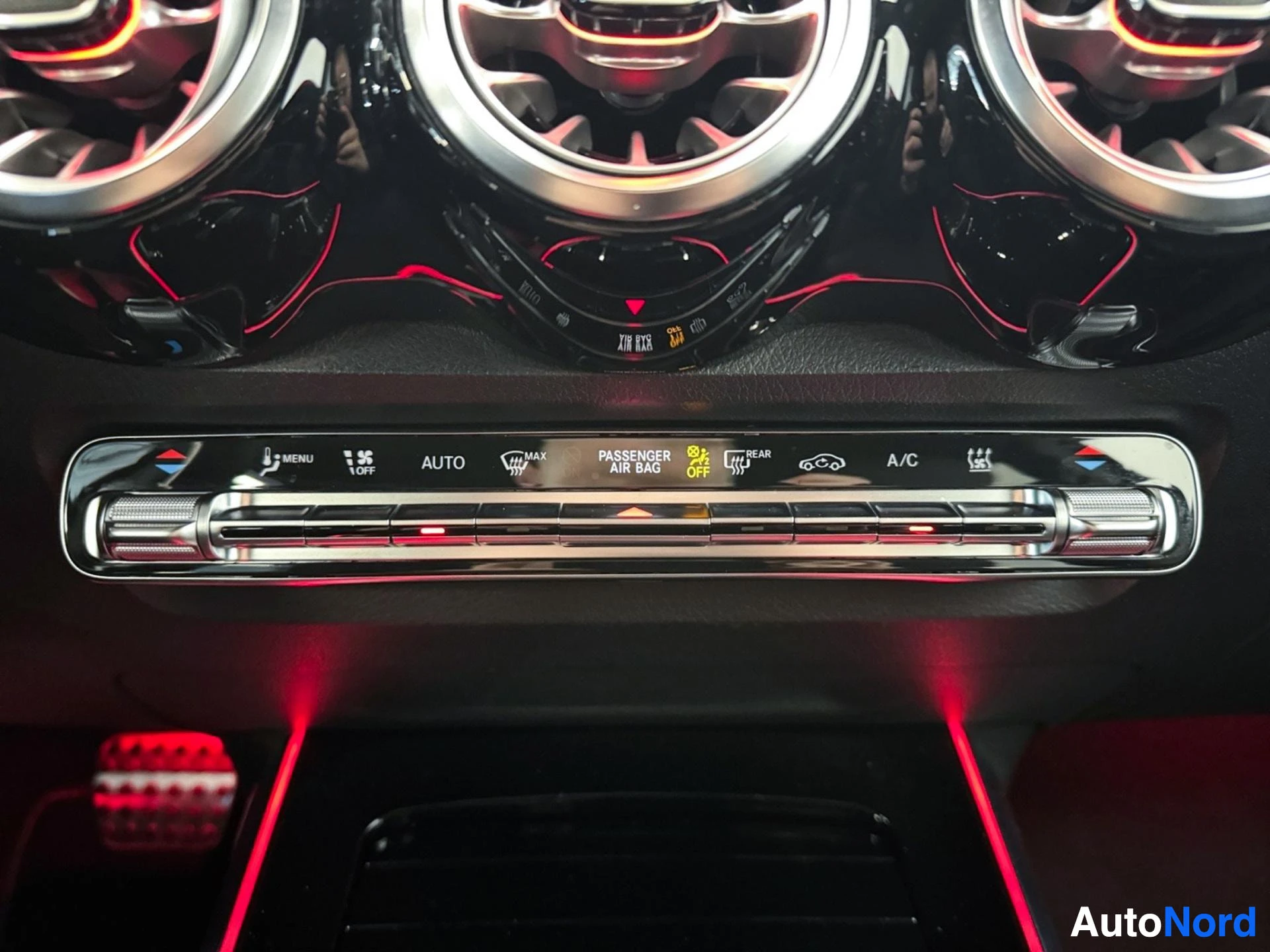 Dashboard with illuminated air vents, climate controls, and red ambient lighting