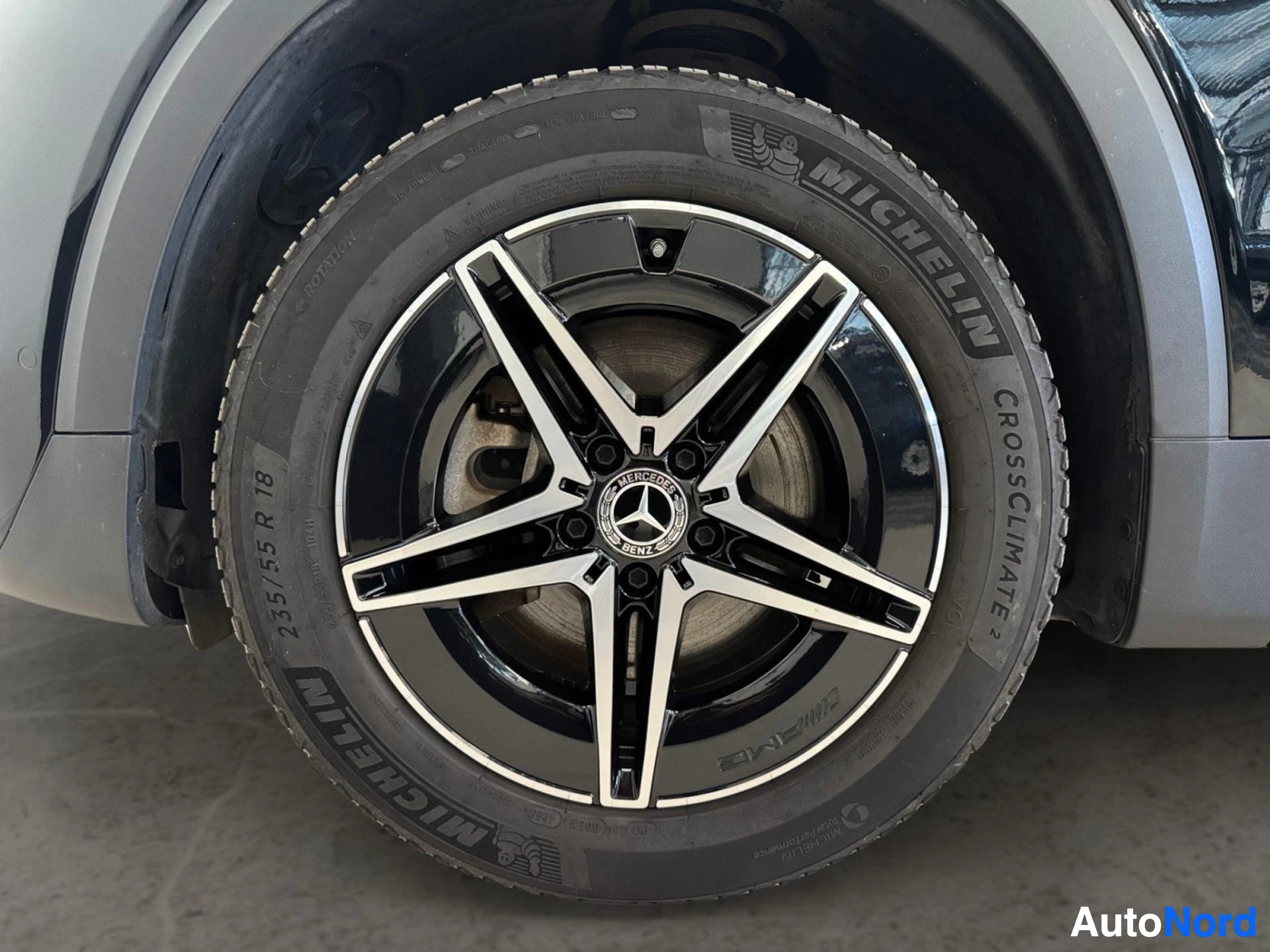 Valkea-mustainen alumiinivanne Michelin-renkaalla ja jarrupaloilla näkyvissä.