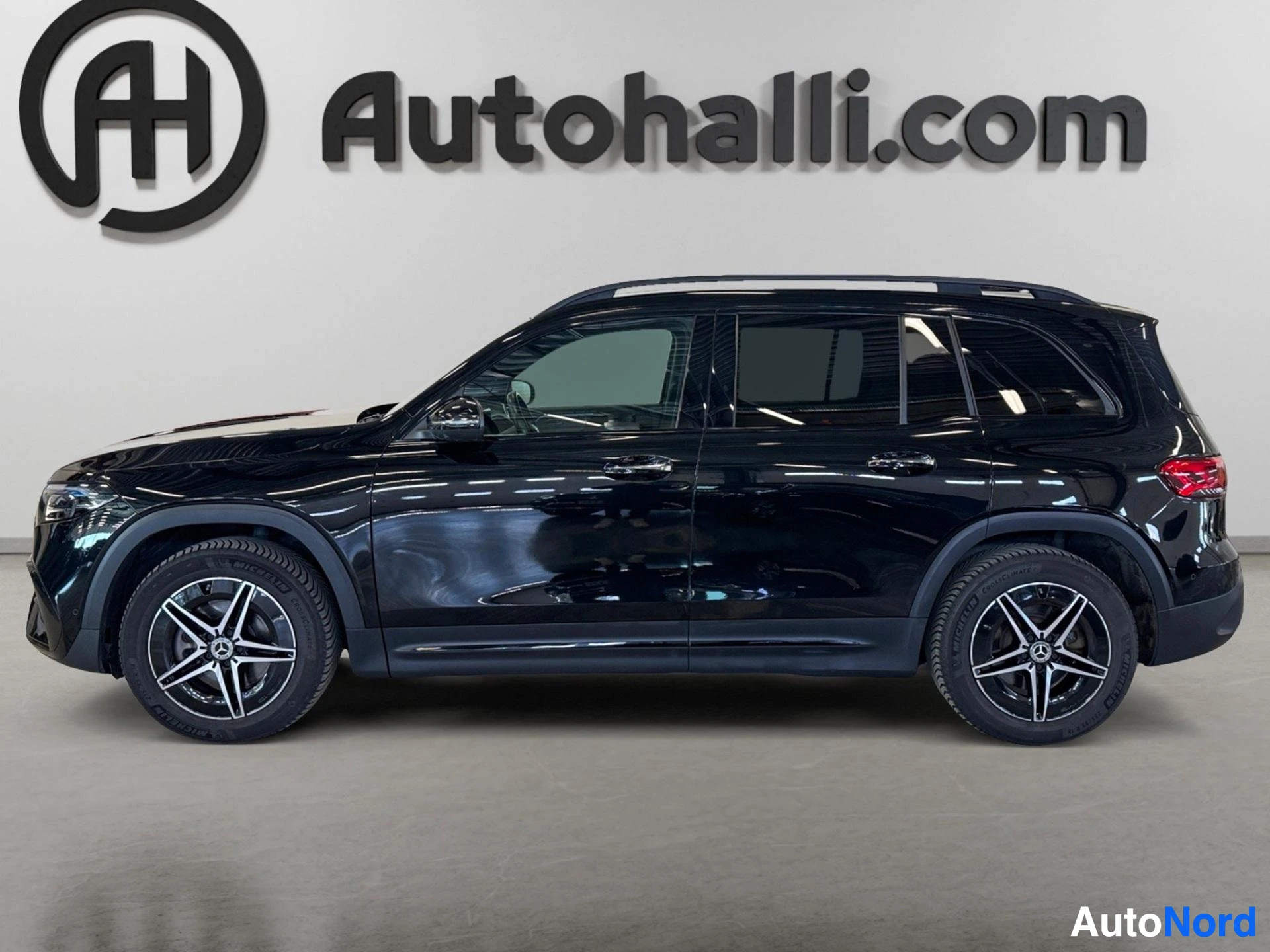 Black SUV viewed from left side profile with white alloy wheels visible