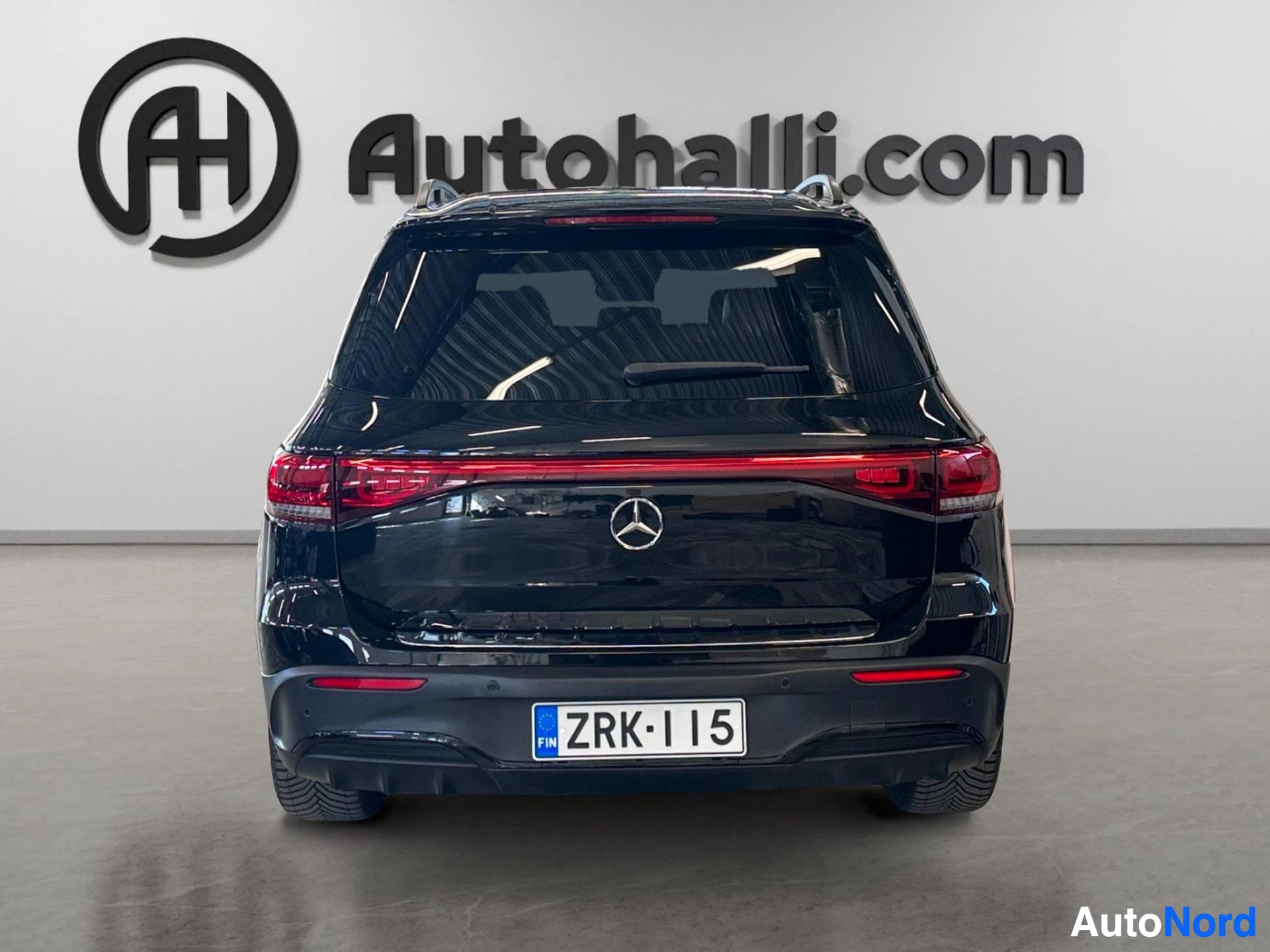 Musta Mercedes-Benz EQB takaa, punaiset takavalaisimet ja Mercedes-logo näkyvissä
