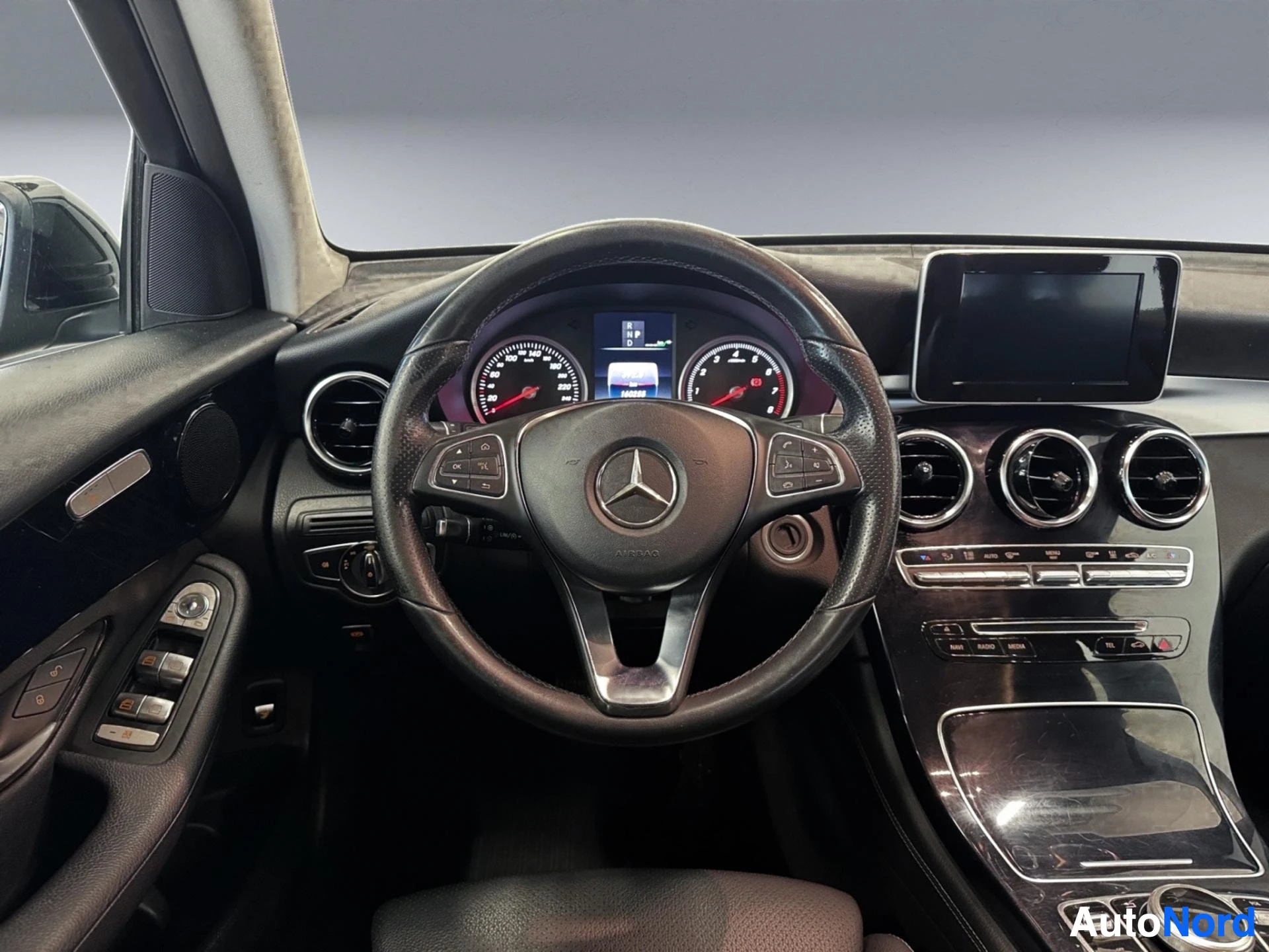 Mercedes-Benz interior with steering wheel, dashboard, and center console controls