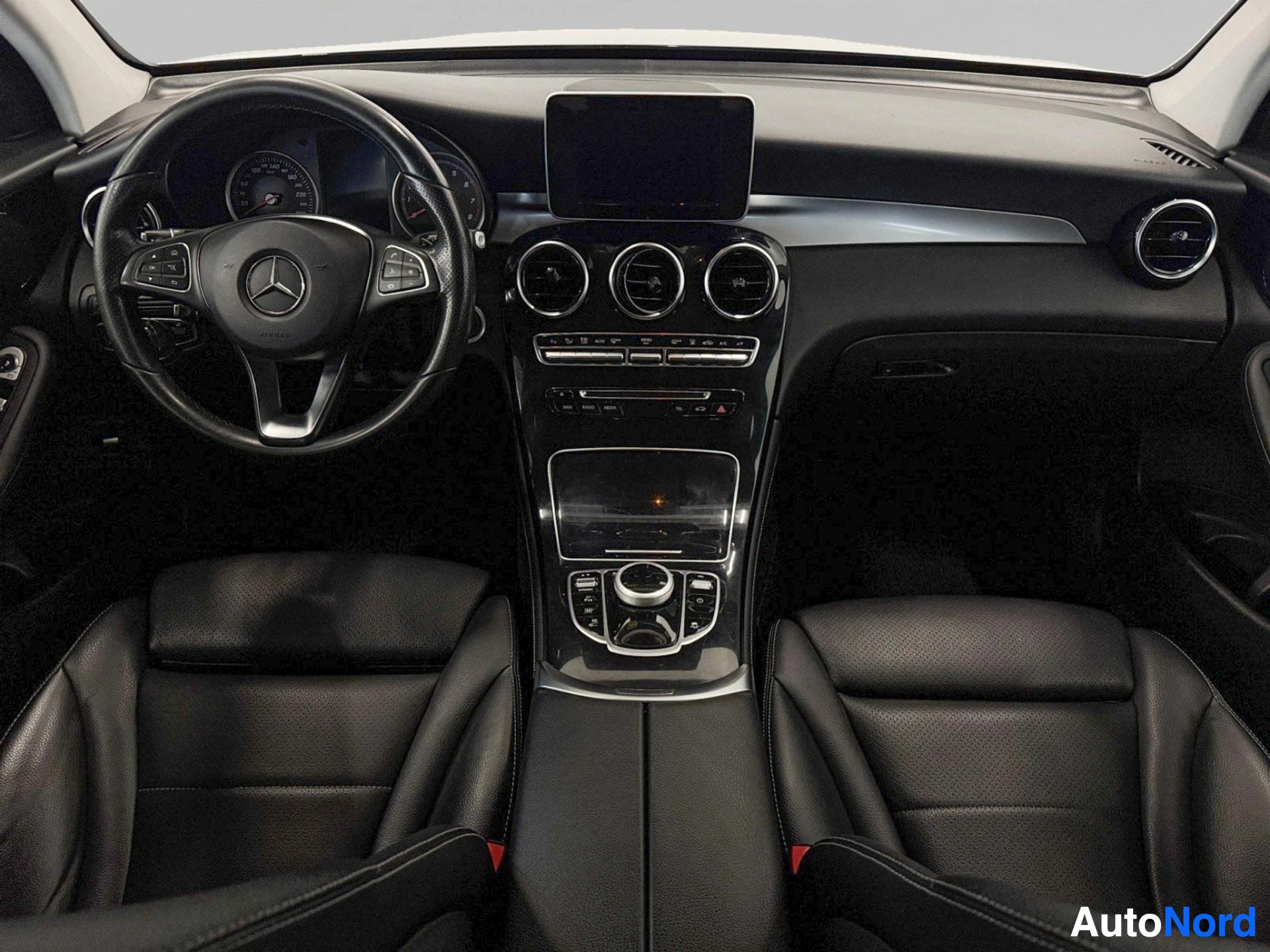 Wide dashboard view showing steering wheel and full center console from driver perspective