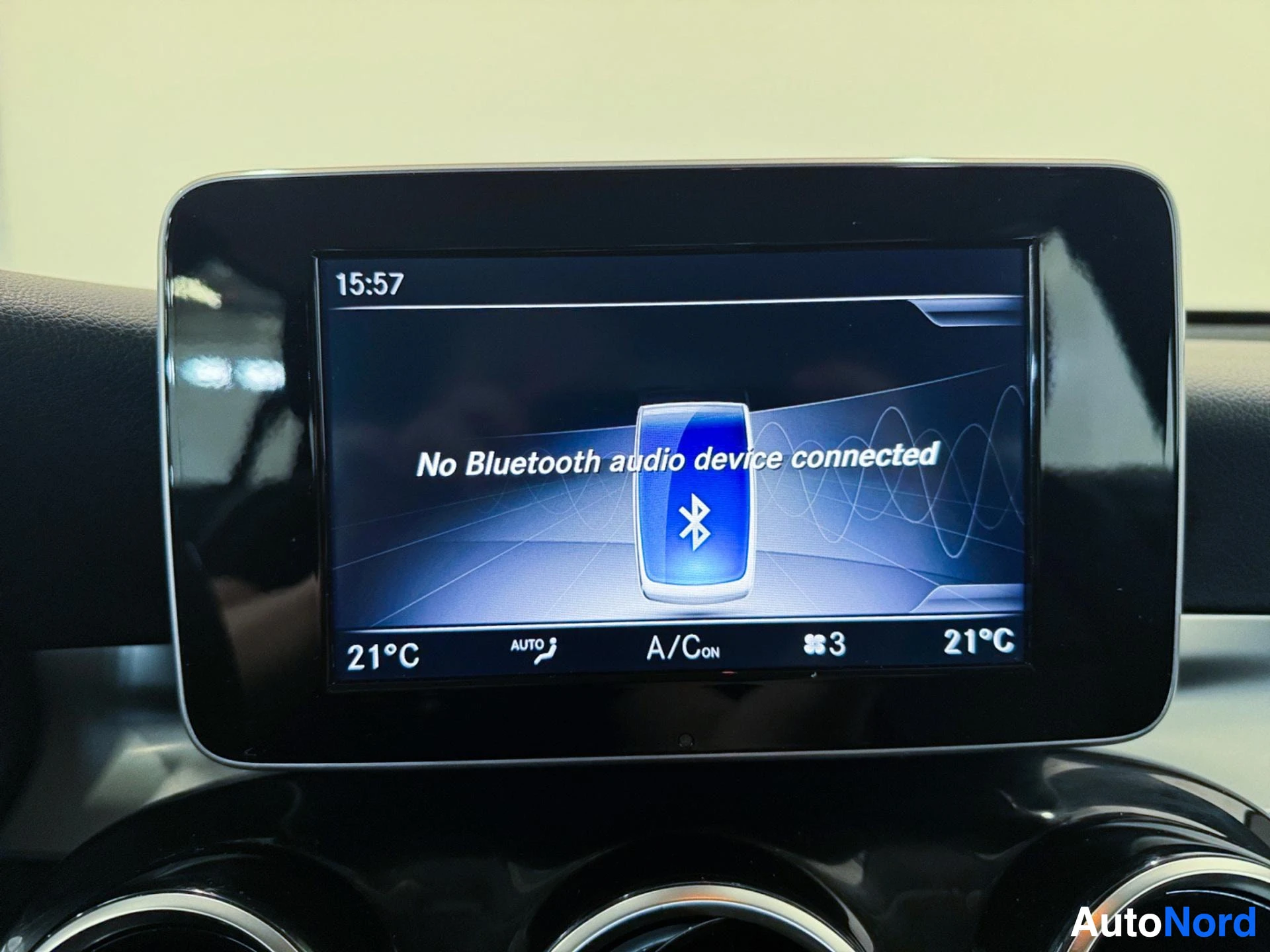 Infotainment display showing Bluetooth connection status and climate information.