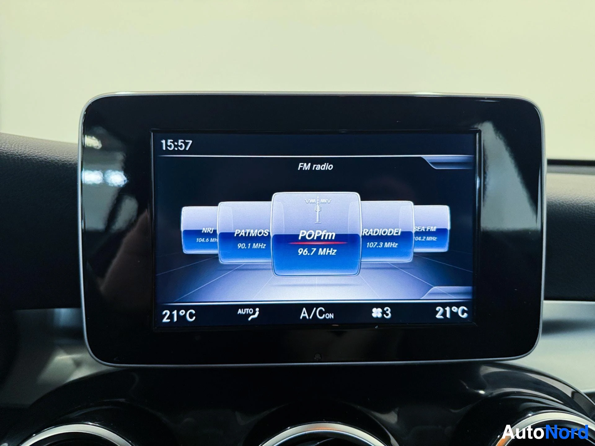 Touchscreen display showing FM radio and climate settings