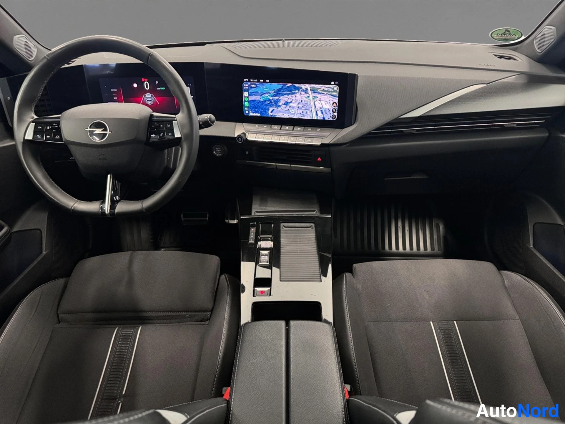 Interior dashboard with steering wheel, infotainment display and gray leather seats