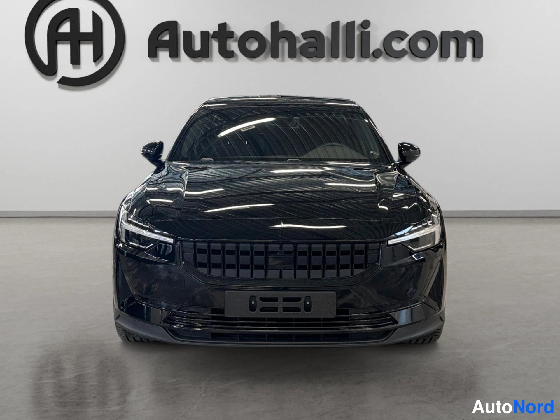 Musta Polestar 2 -sähköauto edestä katsottuna, panoraamikattolasi näkyvissä