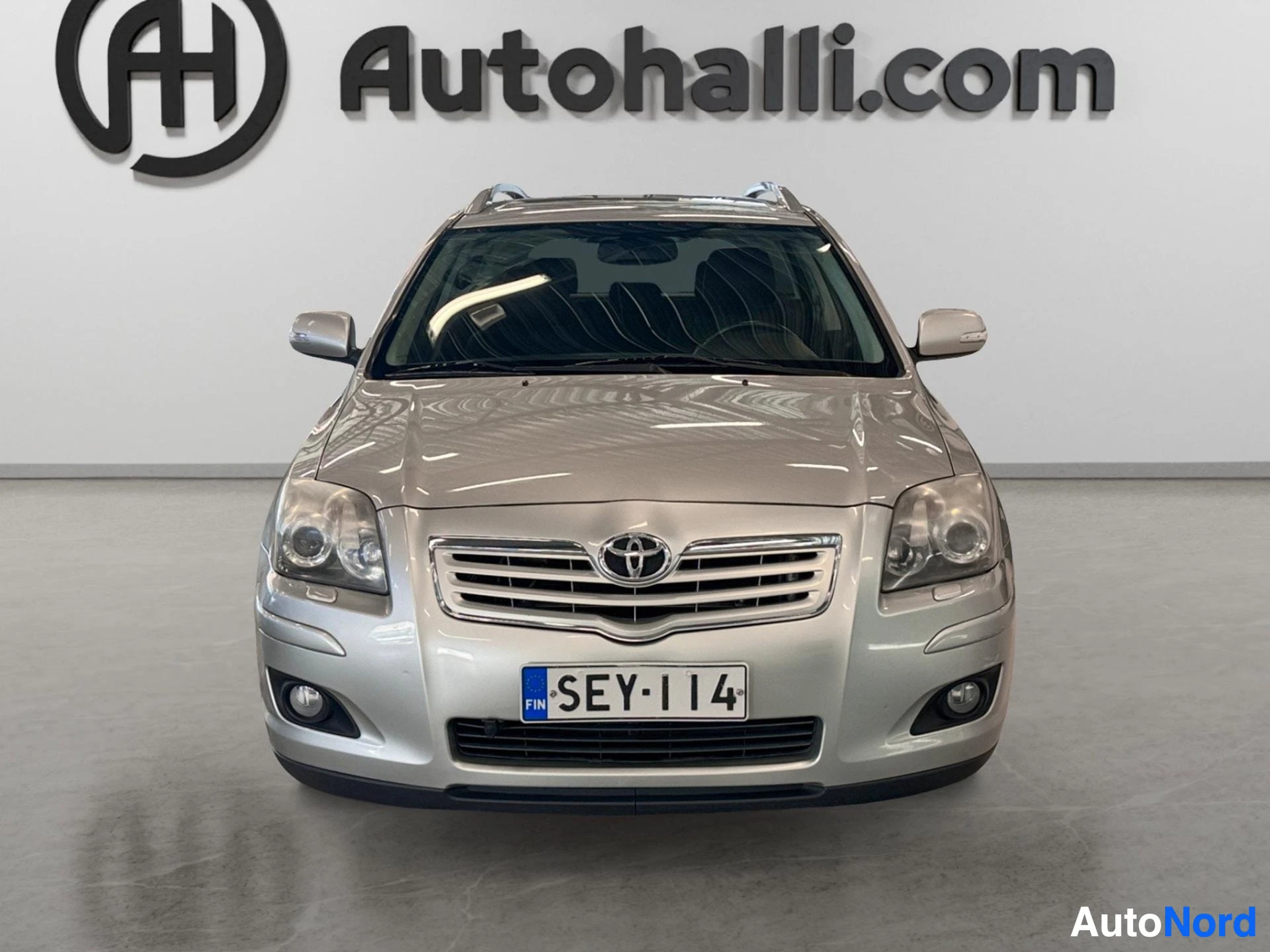 Hopeanvärinen Toyota Avensis farmari etupuolelta, suora etunäkymä