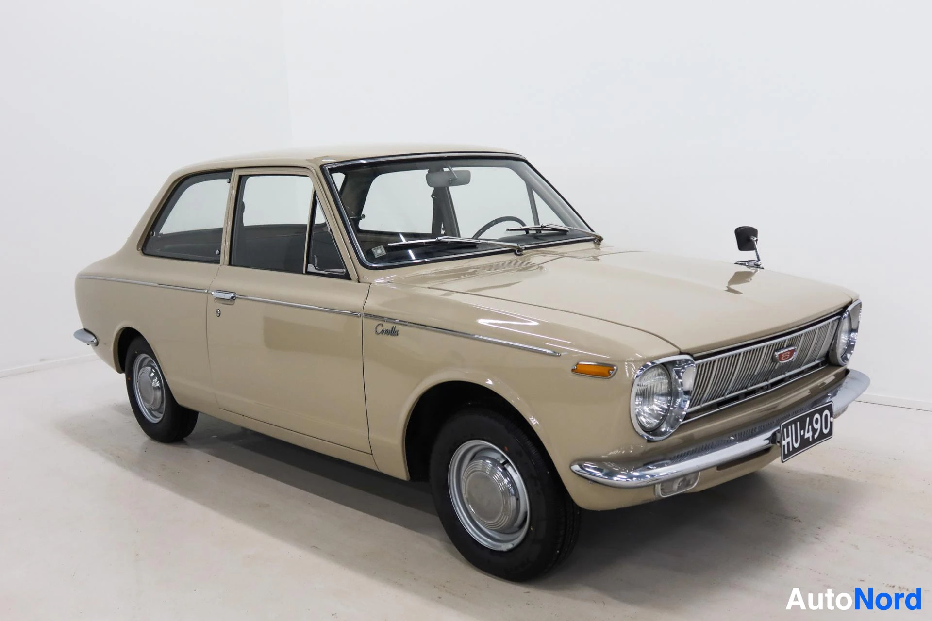 Beige Toyota Corolla three-quarter view with open driver side door