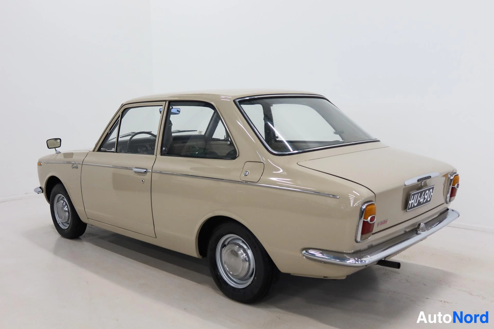 Beige Toyota Corolla rear three-quarter view with both doors open