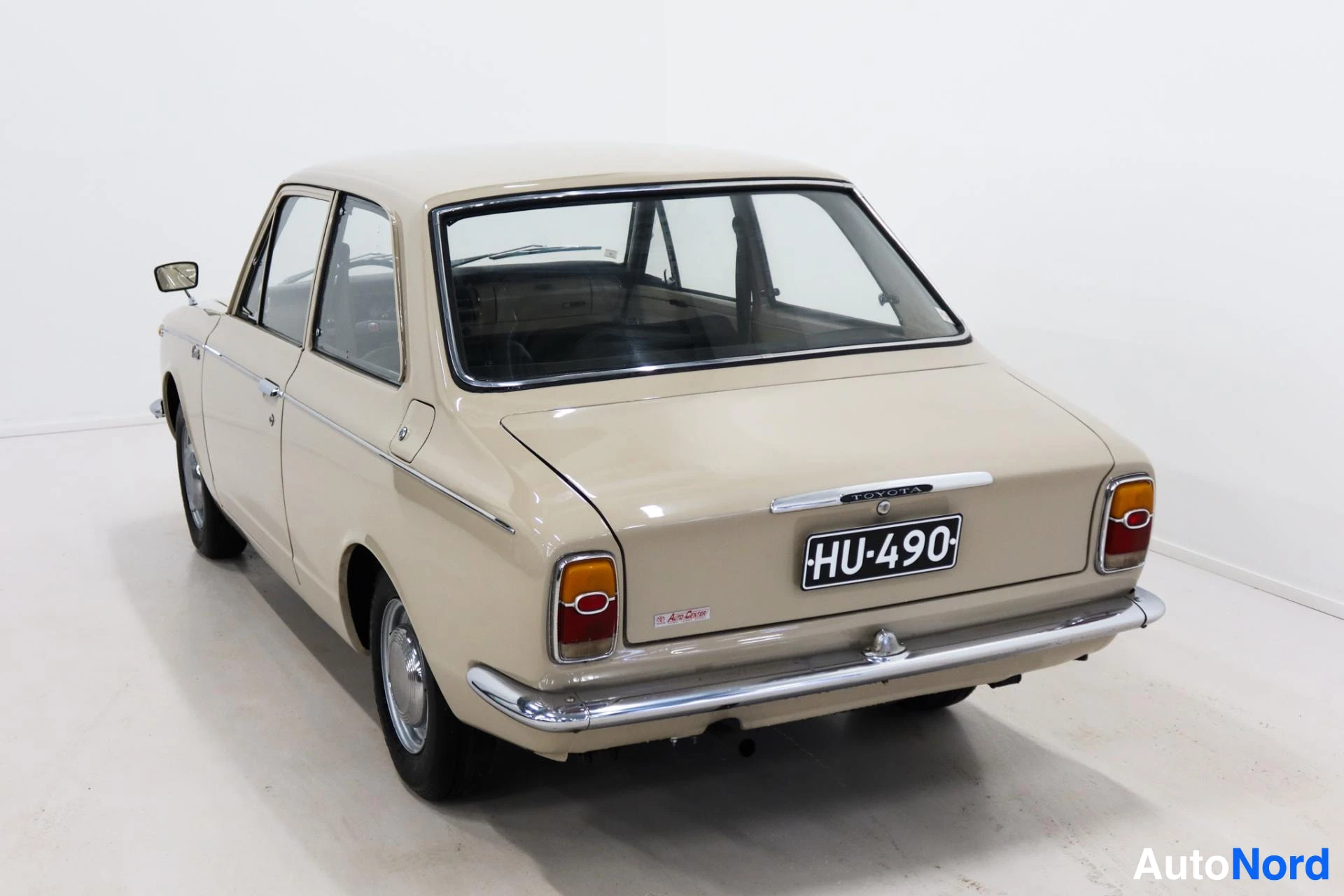Beige Toyota Corolla rear view showing registration plate and taillights
