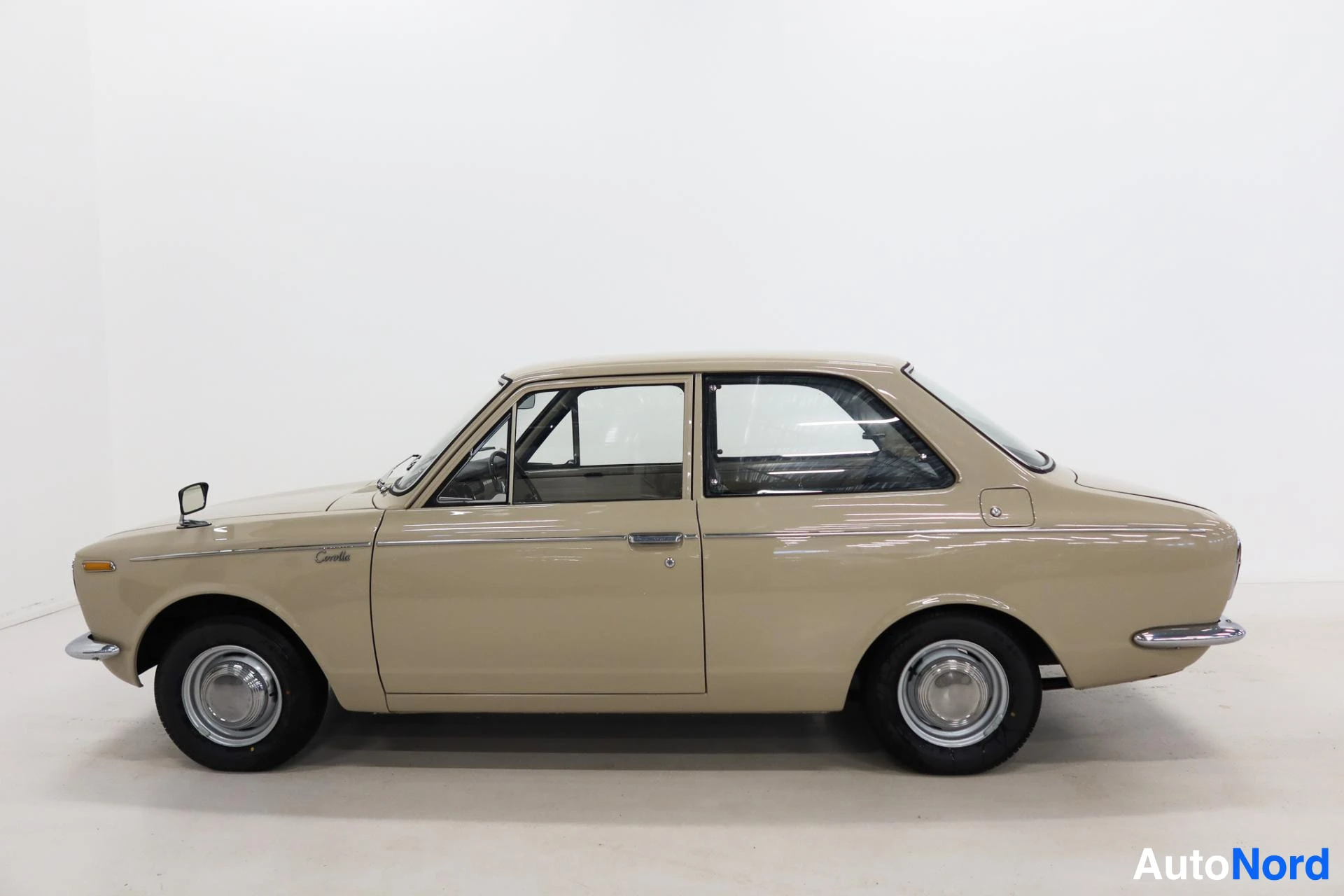 Beige Toyota Corolla viewed from the side with driver door open