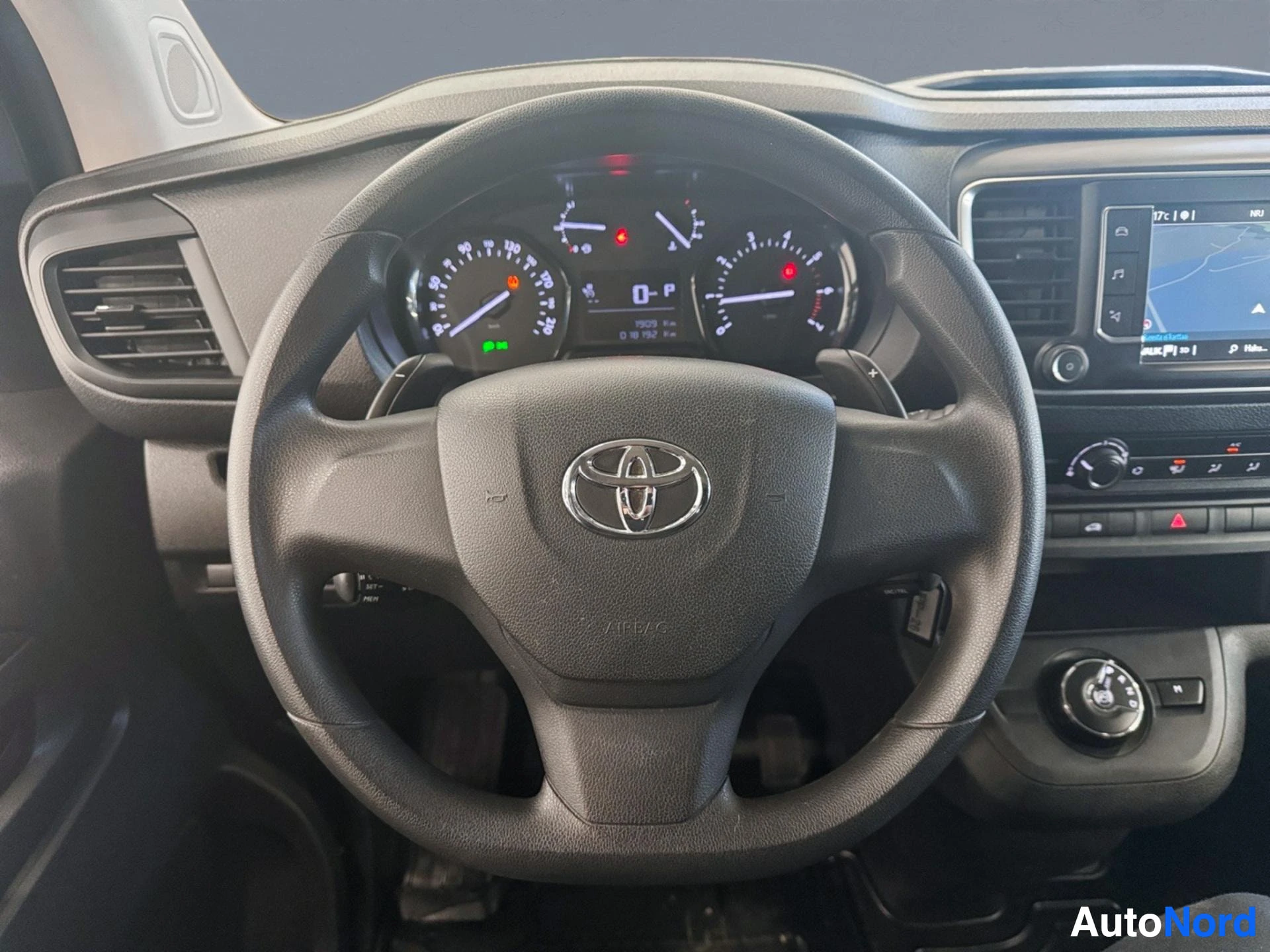 Dashboard and steering wheel with speedometer, fuel gauge, and infotainment system visible