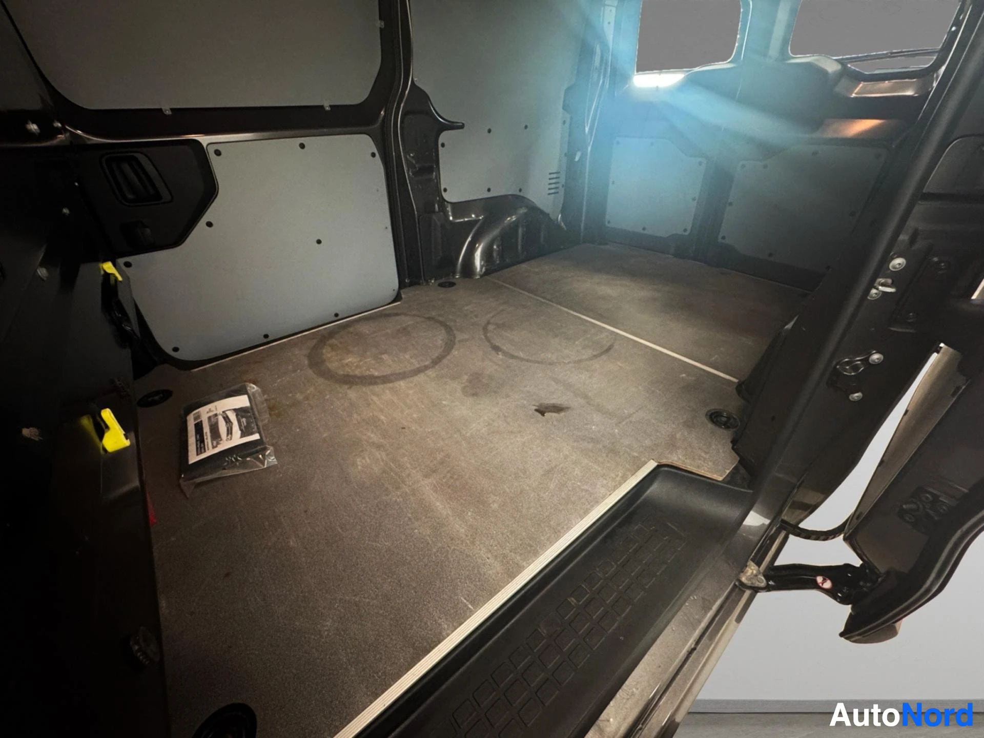 Empty cargo area with carpet flooring and white side panels