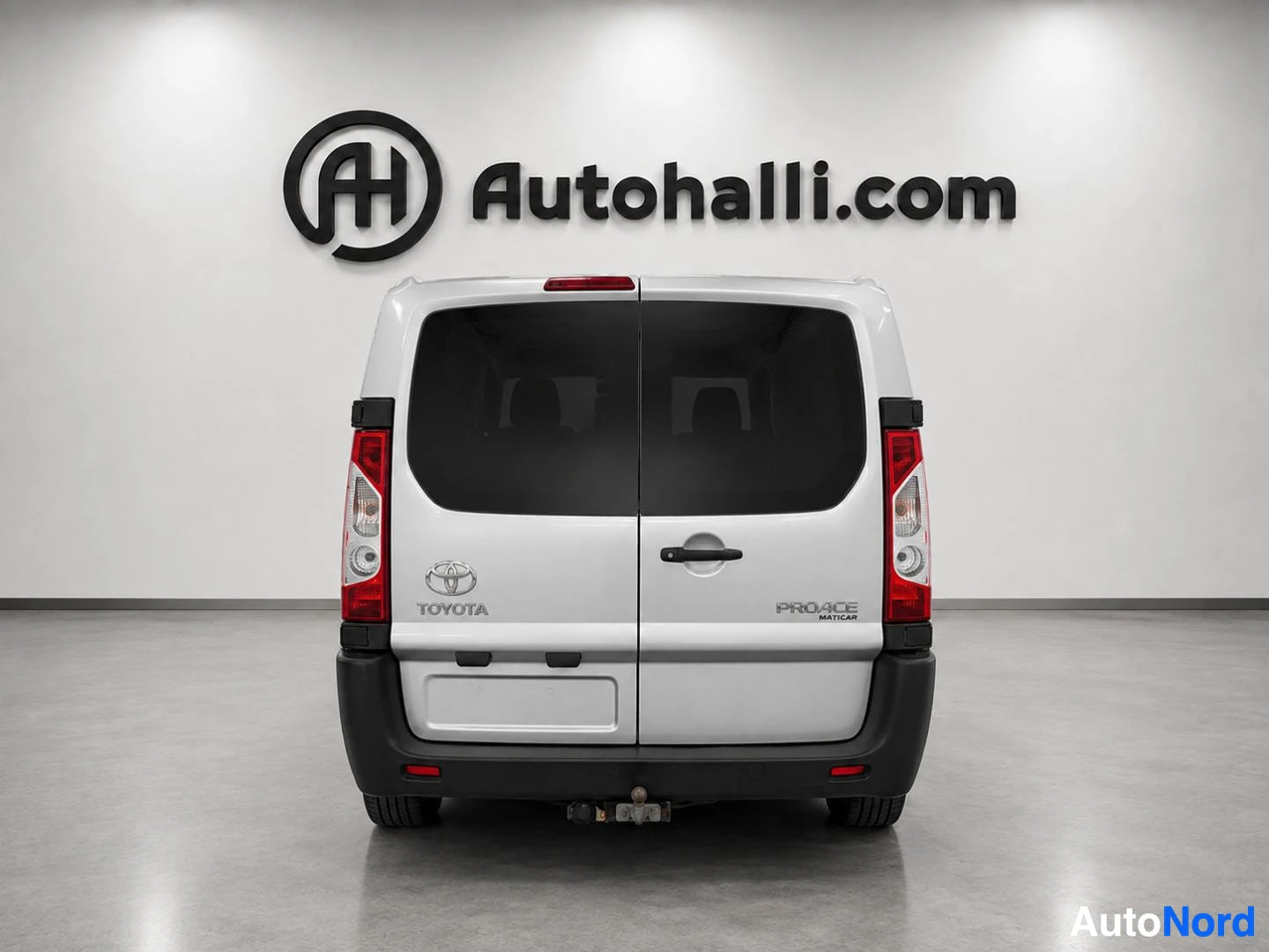 Valkoinen Toyota Proace -pakettiauto takaosasta, punaisten takavalojen ja koukun näkyvissä.