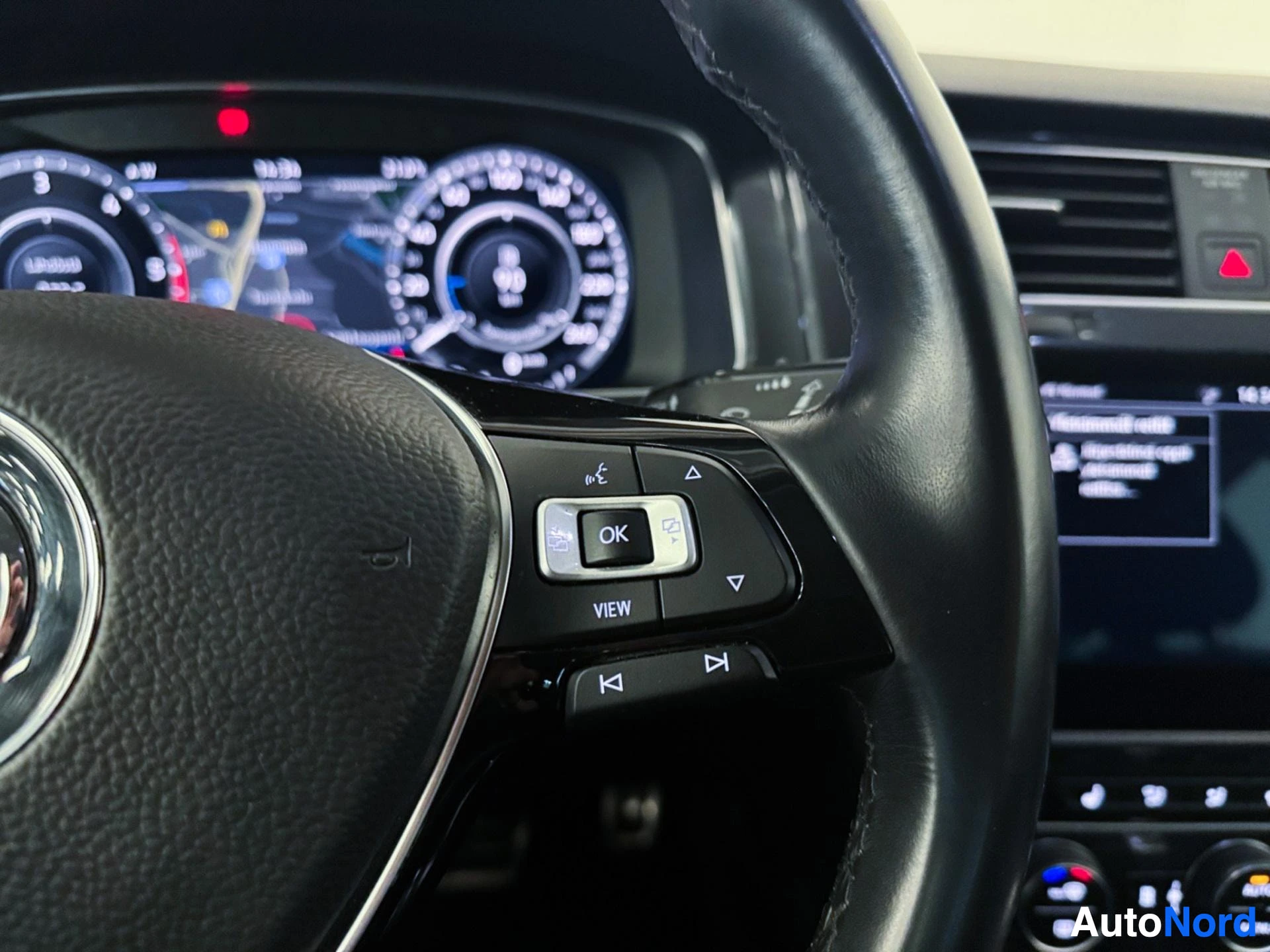 Digital dashboard display showing speedometer and multifunction steering wheel controls