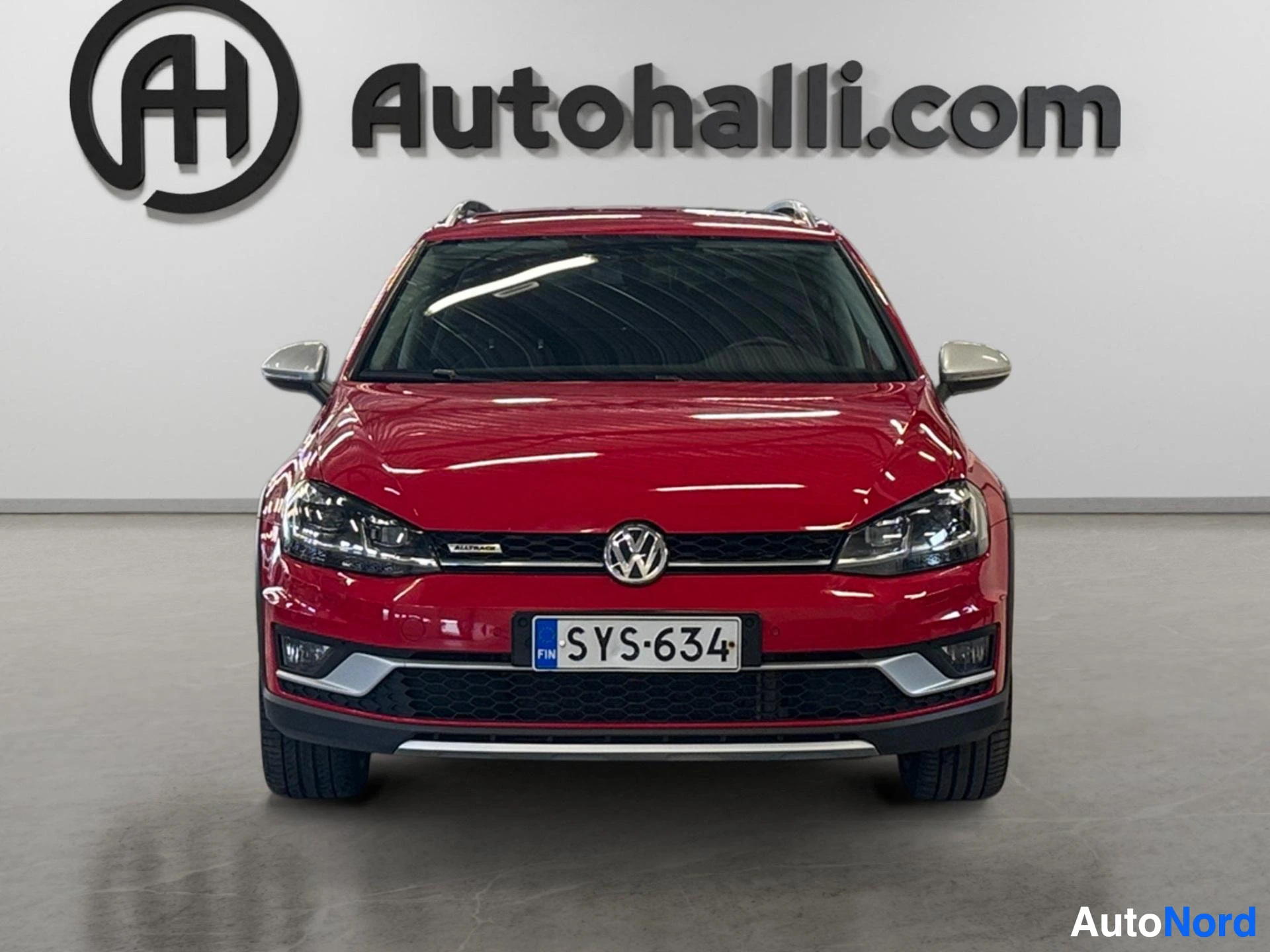 Red Volkswagen Golf Variant Alltrack front view with headlights and grille