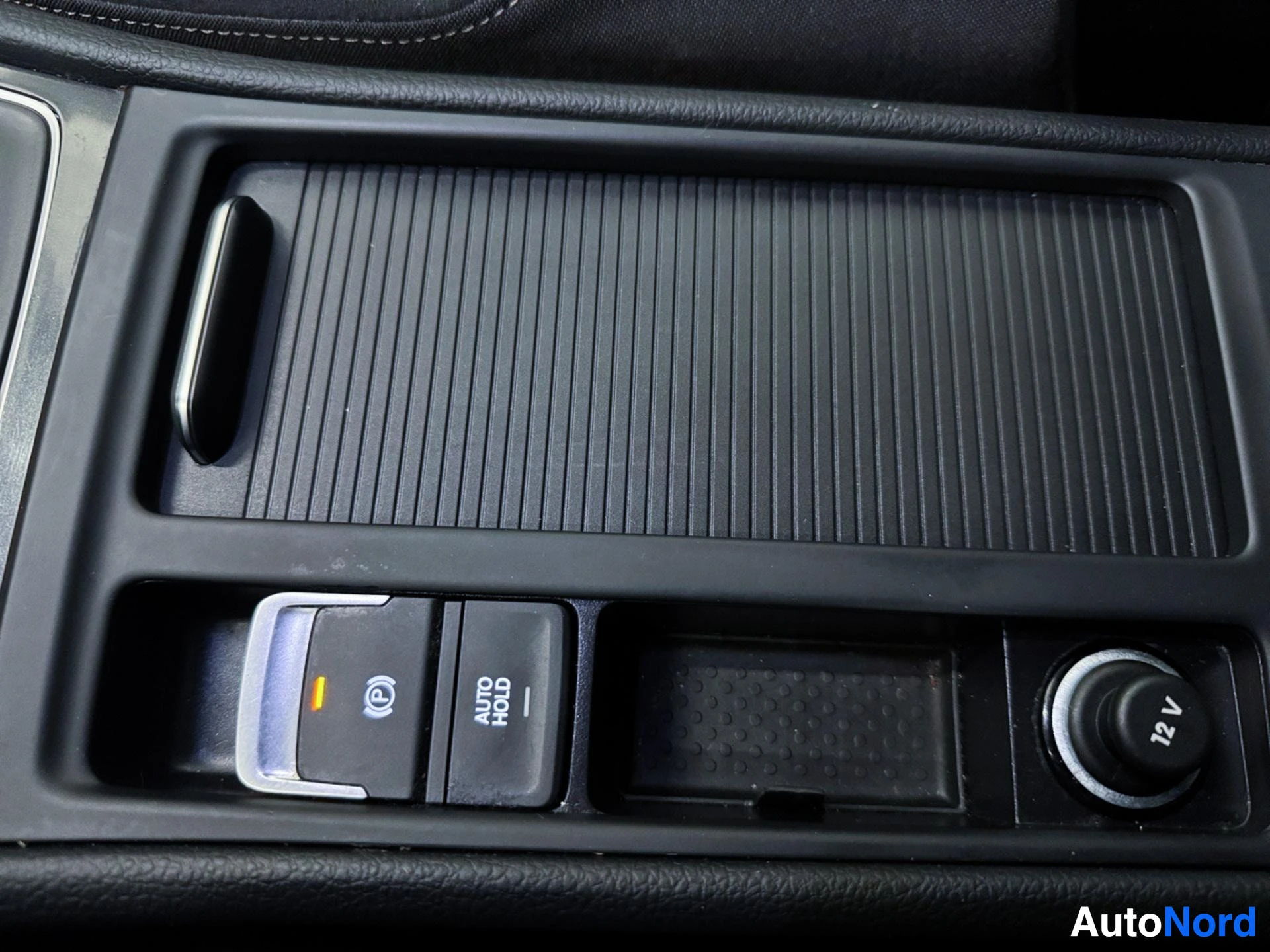 Interior storage compartment with ridged design and control buttons below.