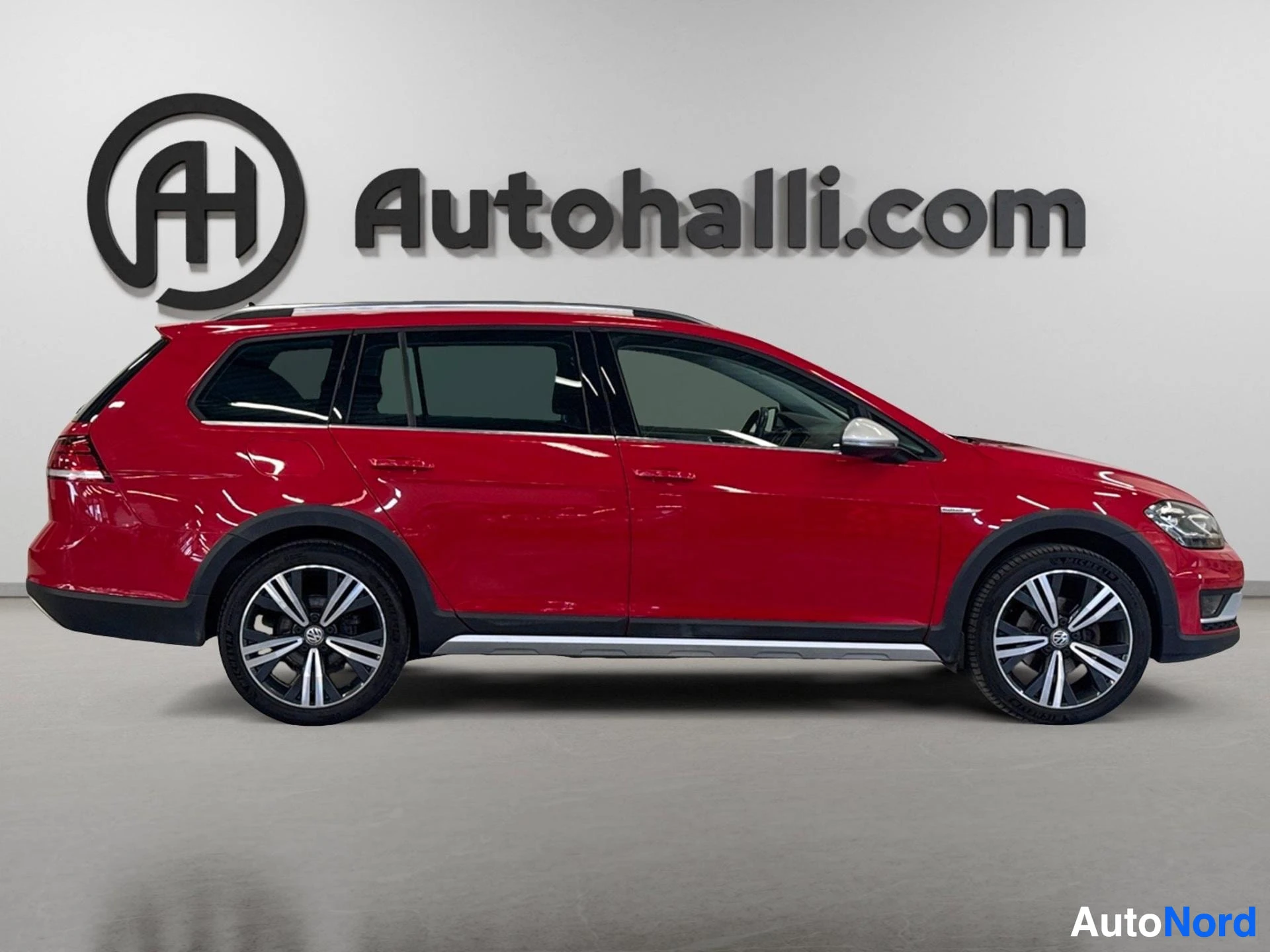 Red Volkswagen Golf Variant Alltrack side profile view with alloy wheels