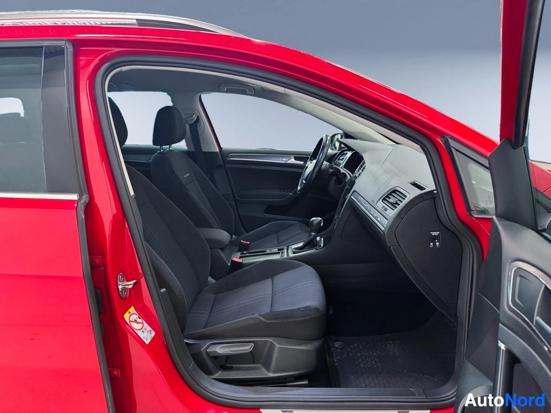 Red Volkswagen Golf front interior with open driver door, dashboard and black seats