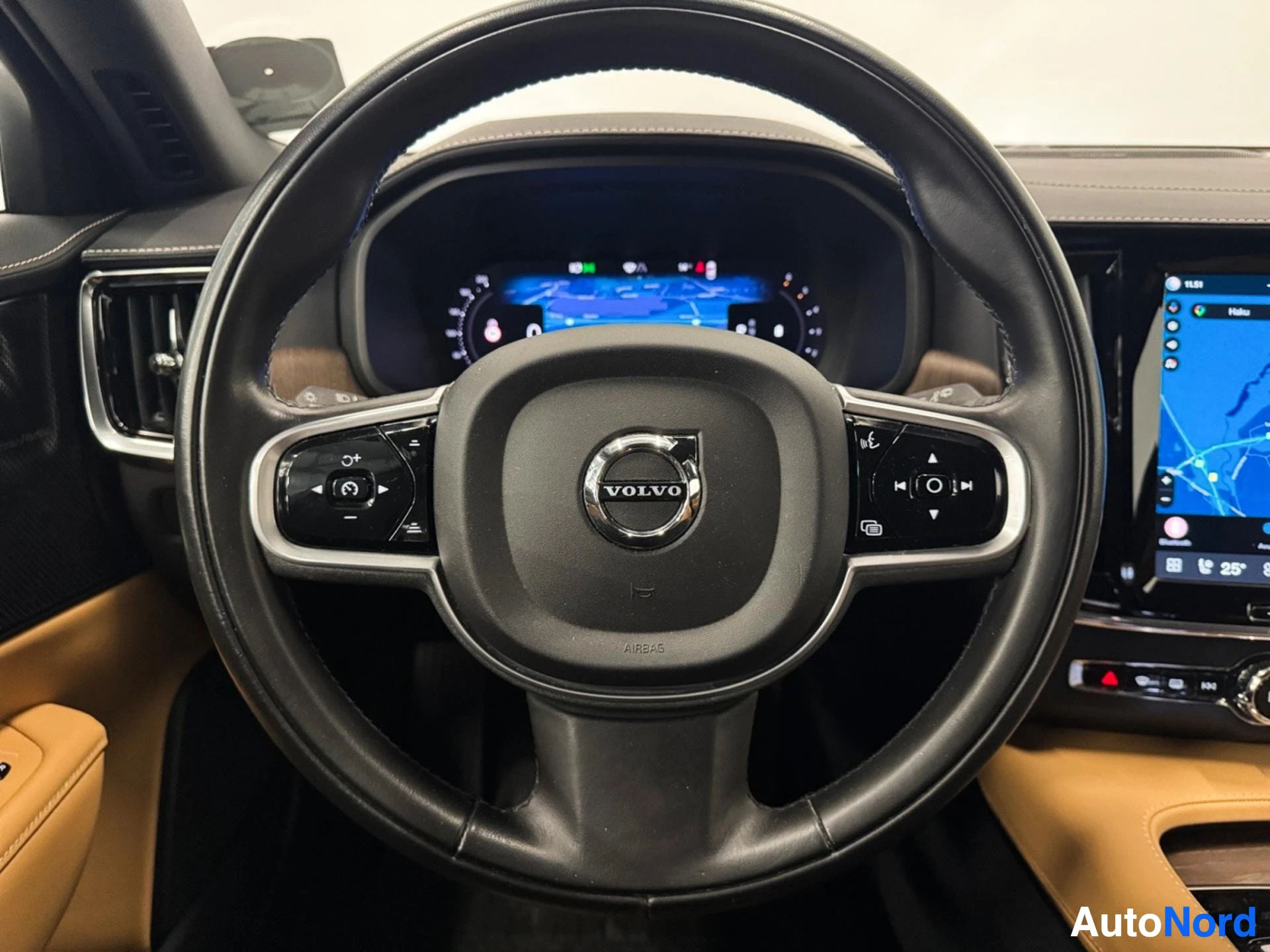 Volvo-logo steeringpyörässä, mittaristo taustalla, nahkapenkit tummansinisellä ja tan väreillä