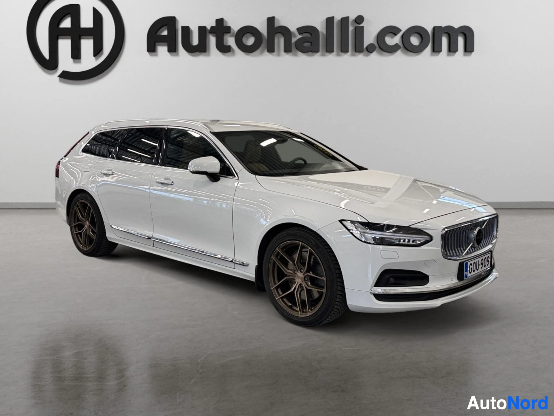 White Volvo V90 wagon viewed from right side angle in showroom