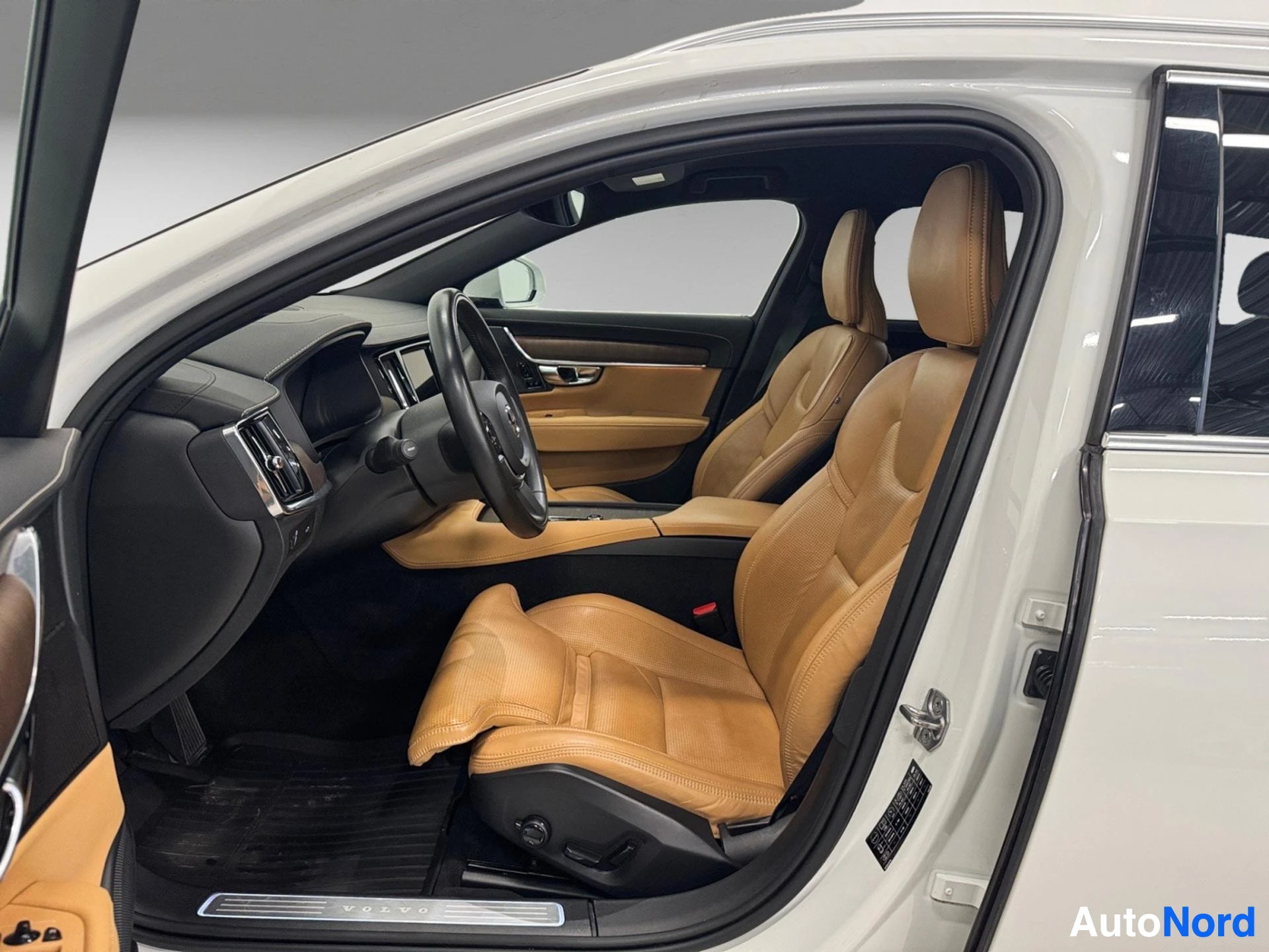 Interior view showing tan leather seats, steering wheel, and dashboard