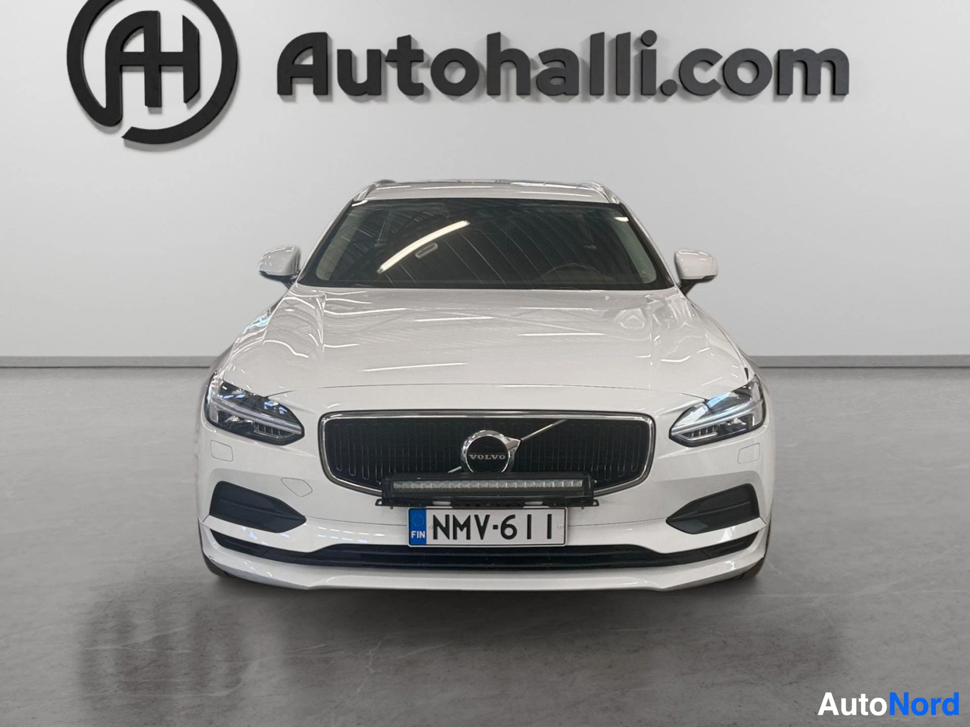 Valkoinen Volvo-farmari etupuoli suoraan, mustaverkkoinen etusäleikkö ja LED-ajovalot