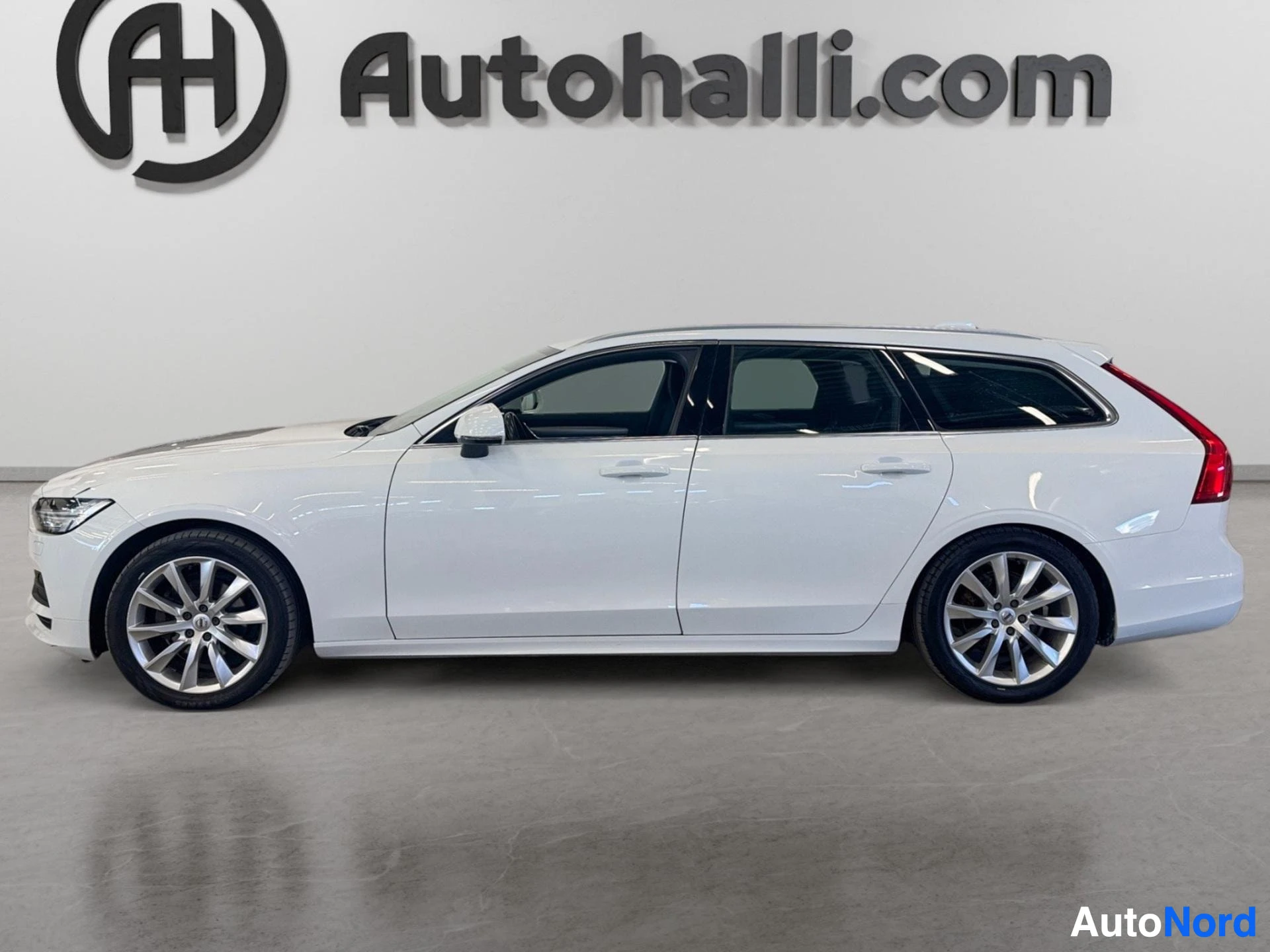 Valkoinen Volvo V90 farmari sivusta, oikealta puolelta näkyvissä etupää